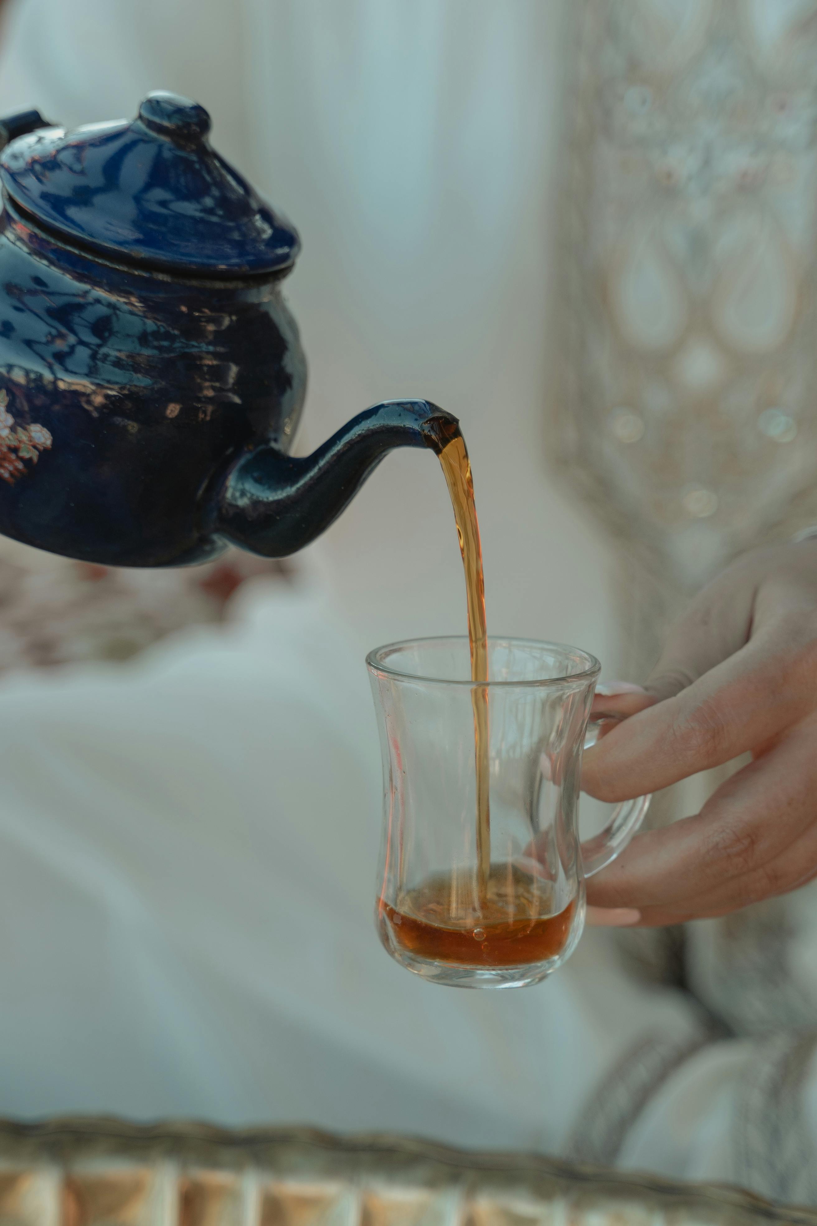A woman's hand pouring a cup of tea | Source: Pexels