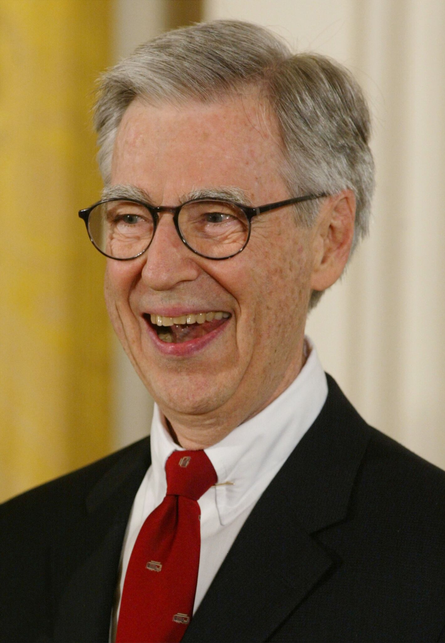 Fred Rogers smiles after receiving the Presidential Medal of Freedom Award from U.S. President George W. Bush, during a ceremony at the White House | Getty Images