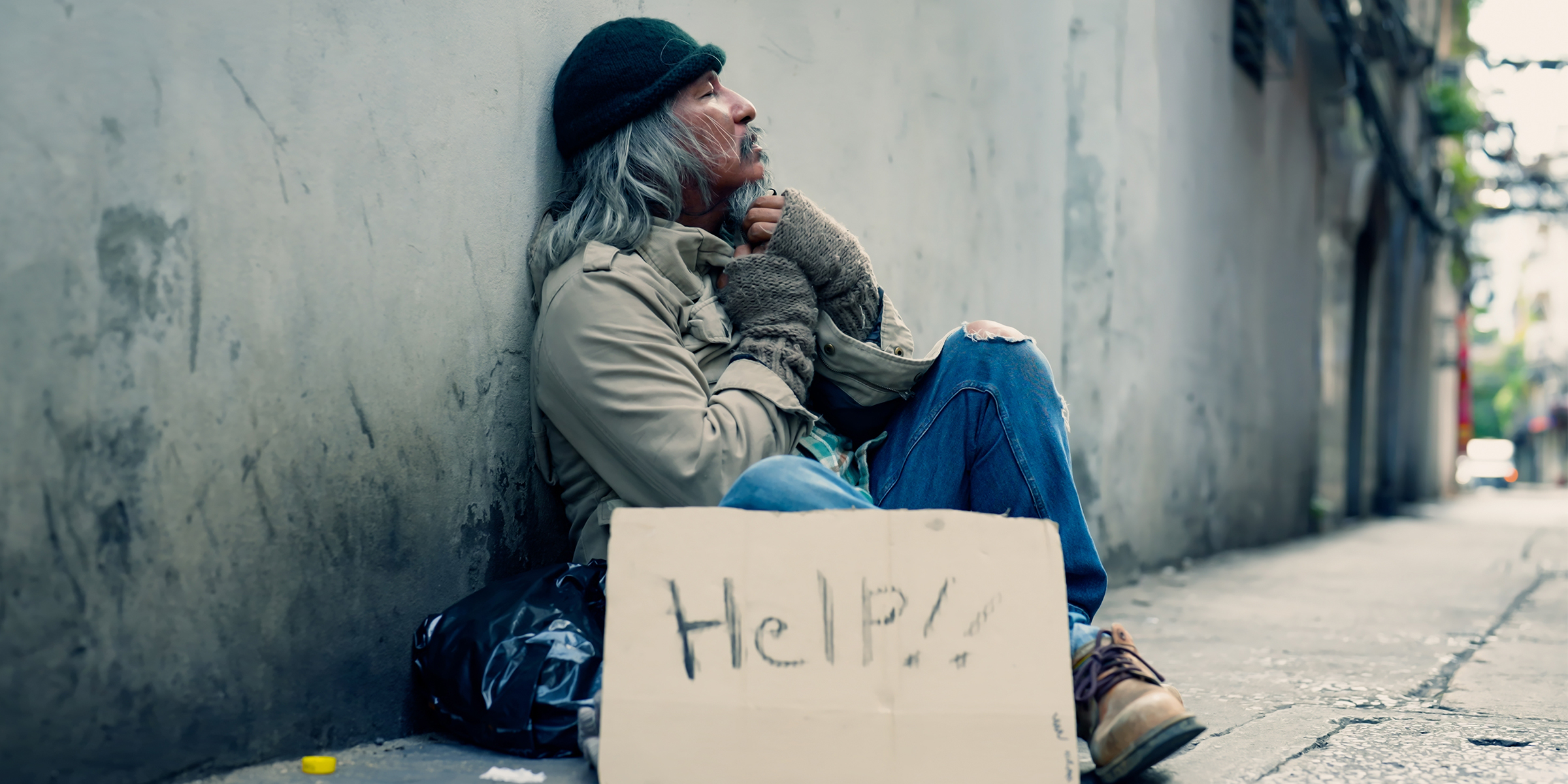 A homeless man with a cardboard signage | Source: Shutterstock