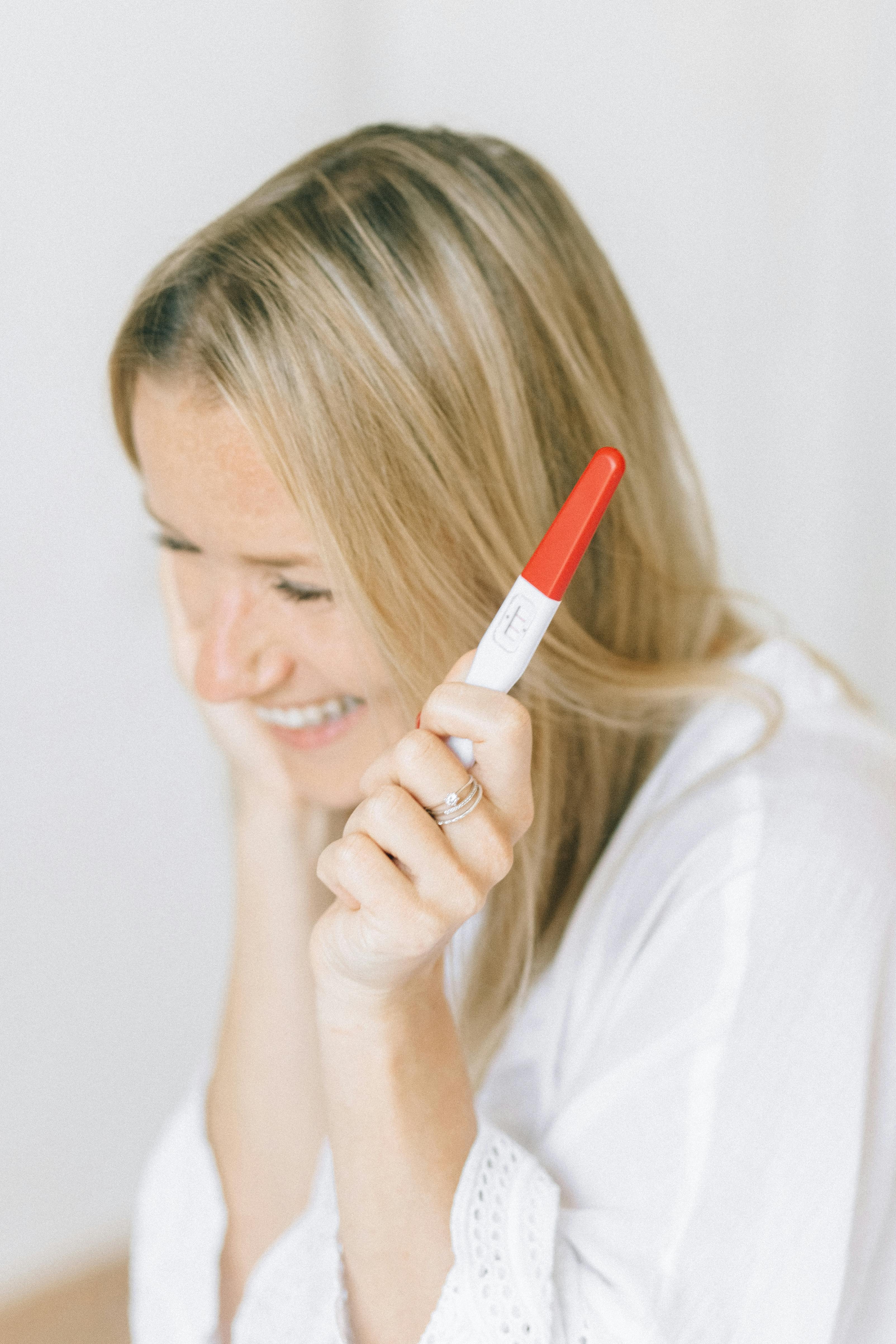 A woman holding a pregnancy test | Source: Pexels