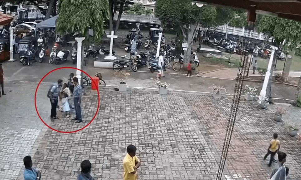 Le bombardier présumé des attentats touche la tête d'une petite fille devant le temple de San Sebastian à Negombo, au Sri Lanka Image. | Source : Hindustan Times/YouTube Le bombardier présumé des attentats touche la tête d'une petite fille devant le temple de San Sebastian à Negombo, au Sri Lanka Image. | Source : Hindustan Times/YouTube