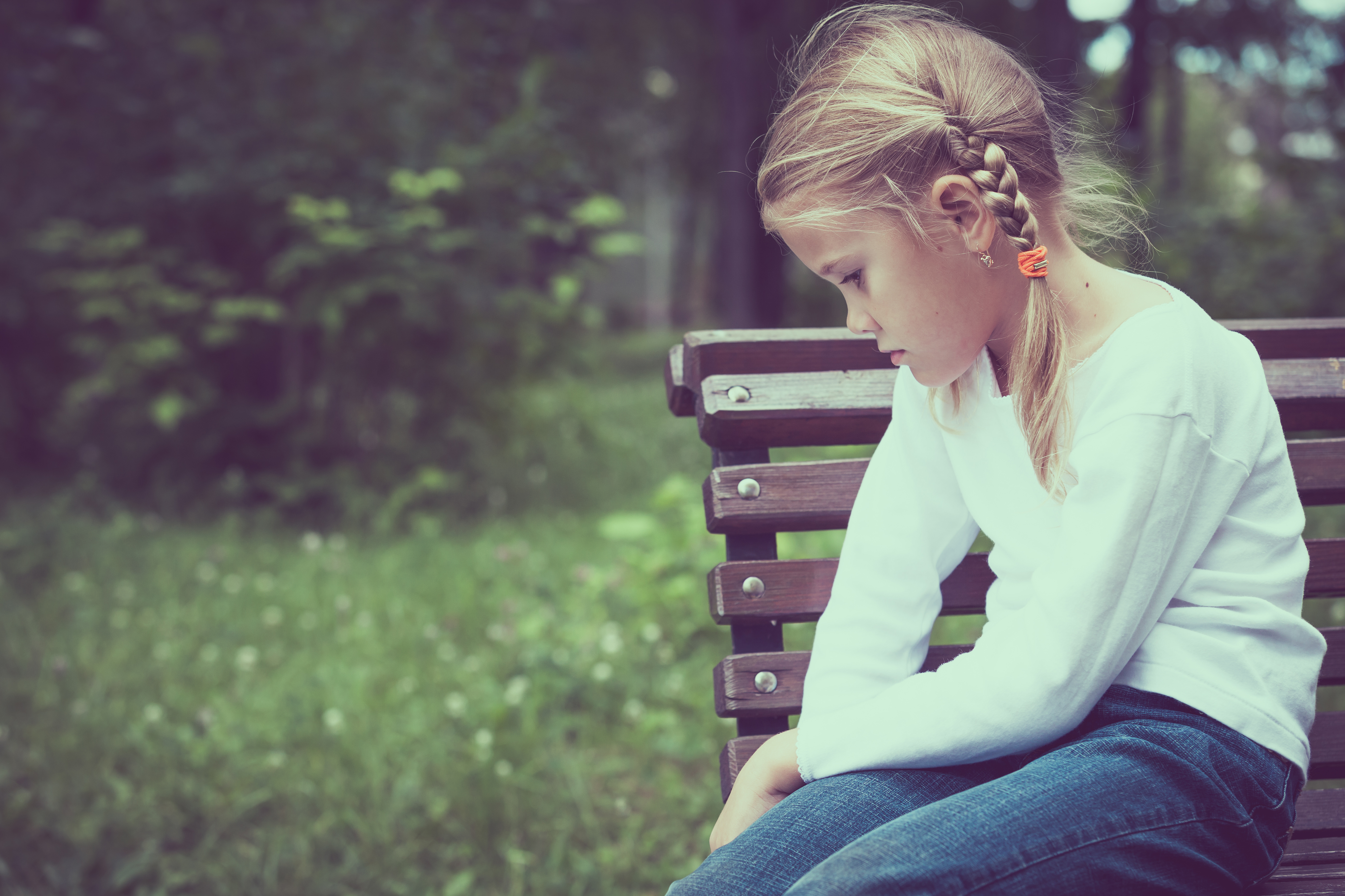 Una niña sentada en un banco |  Fuente: Shutterstock