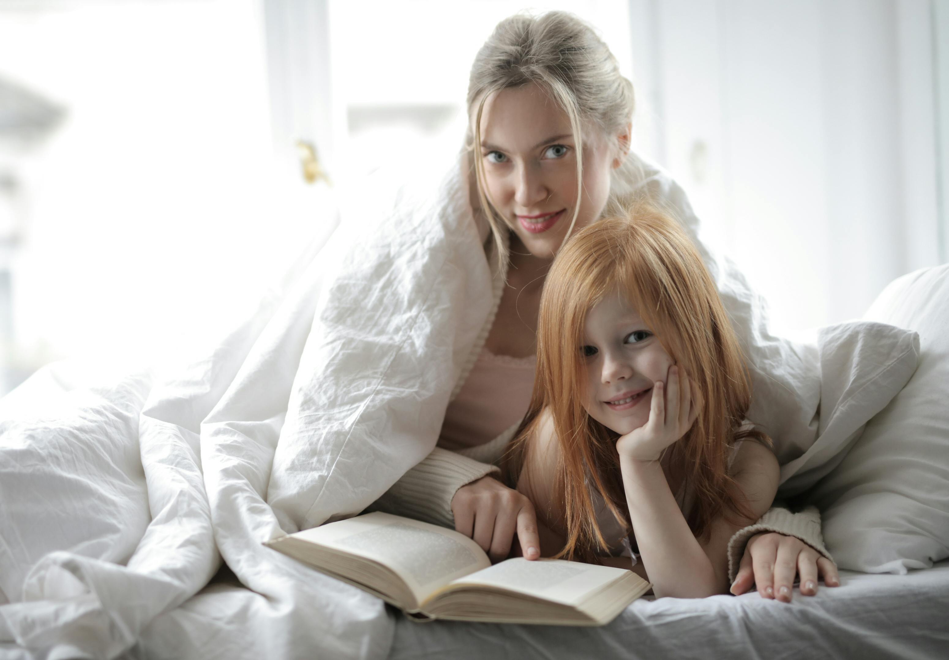 A mother and her daughter reading a book together | Source: Pexels