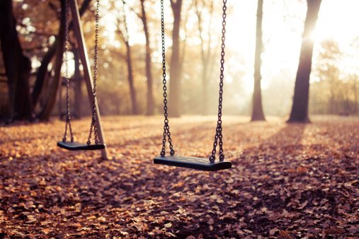 Two swings on playground in sunlight.| Photo: Getty Images