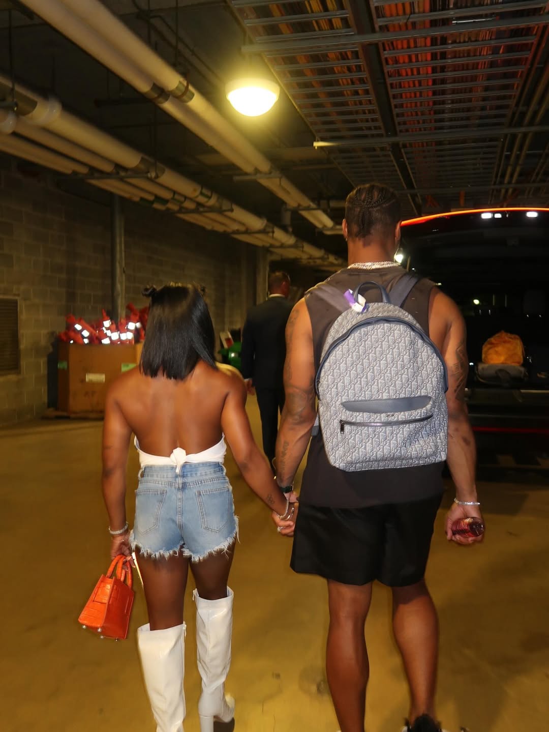 Simone Biles and Jonathan Owens holding hands in a parking area, from her post dated August 12, 2025 | Source: Instagram/simonebiles