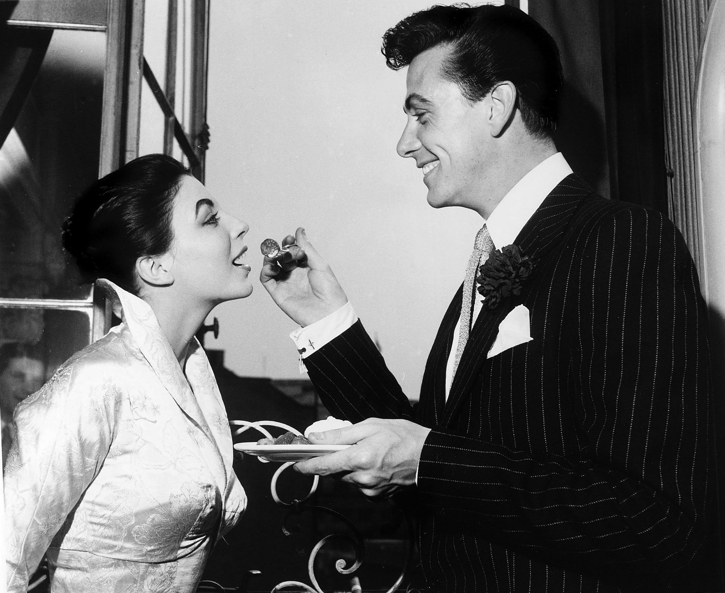 Maxwell Reed and Joan Collins enjoy strawberries and cream at their wedding reception. 25 May 1952, London, England | Source: Getty Images 