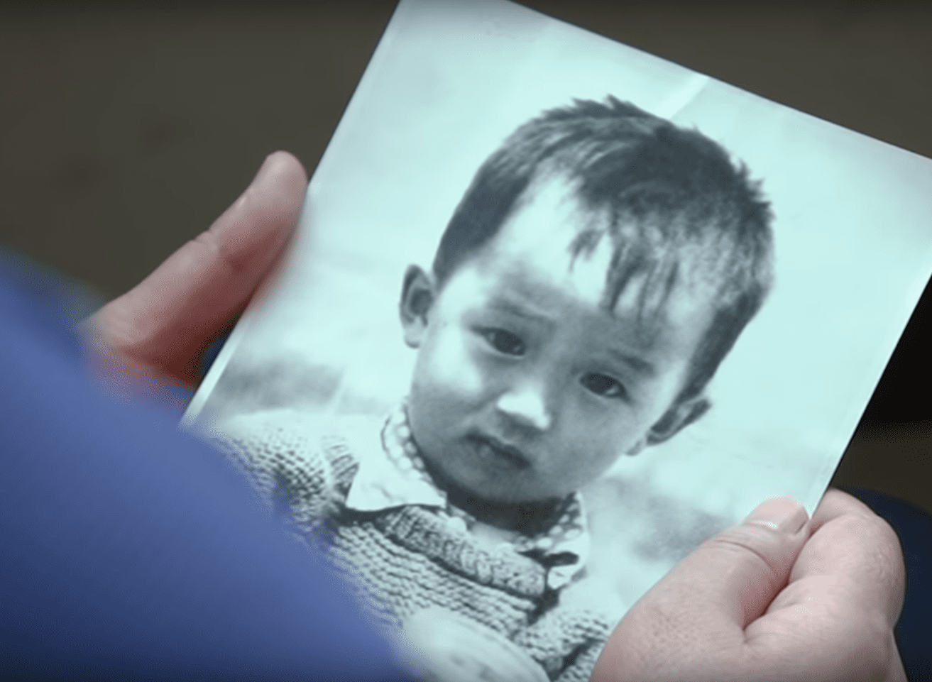 Li Jingzhi sosteniendo una fotografía de la infancia de su hijo Mao Yin. | Foto: YouTube/South China Morning Post