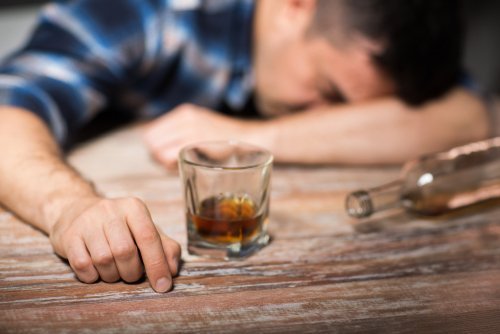 A man sleeping with his head on the table after drinking alcohol. | Source: Shutterstock.