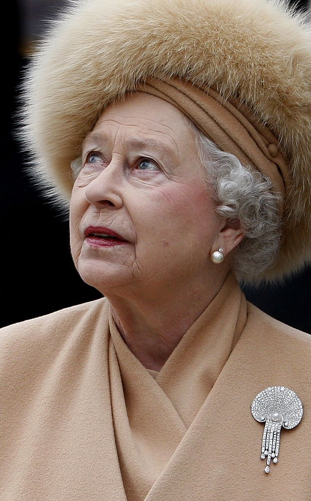  Queen Elizabeth II looks up at the statue of her mother as she attends the unveiling of a new statue of Queen Elizabeth, the Queen Mother on the Mall on February 24, 2009, in London, England. | Source: Getty Images.