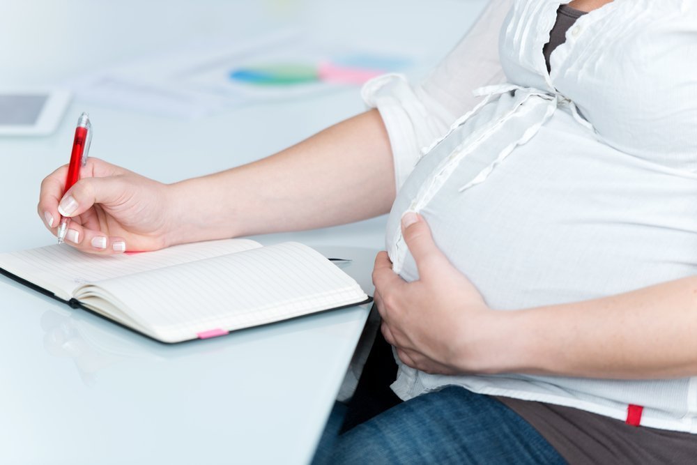 Pregnant teacher planning lessons | Shutterstock