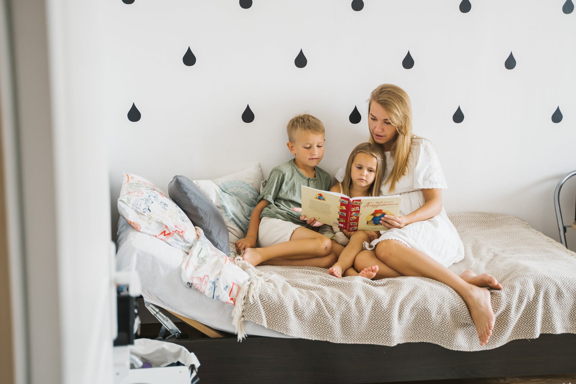 A mother reading a story to her kids | Source: Pexels