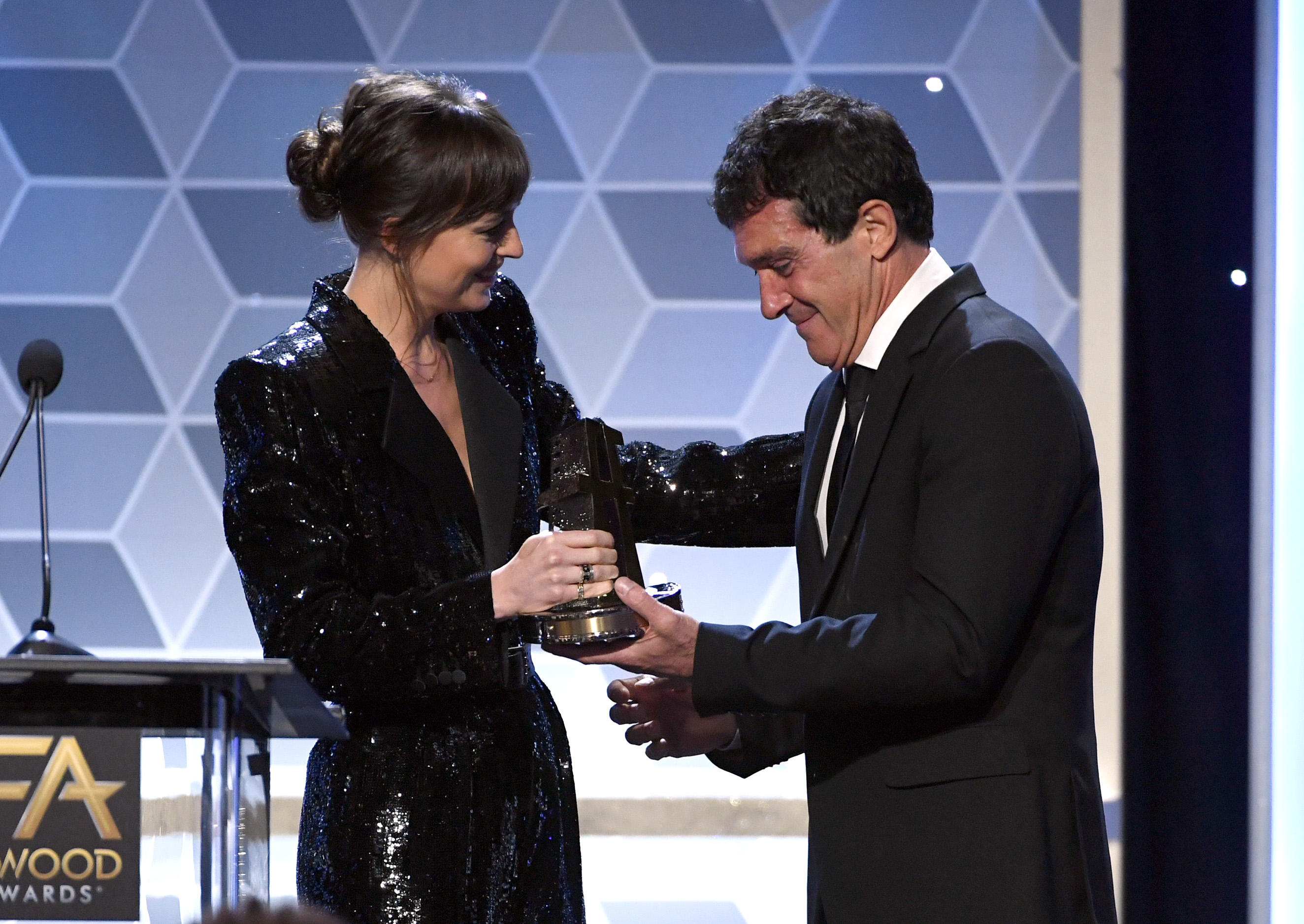 Antonio Banderas accepts the Hollywood Actor Award from Dakota Johnson onstage during the 23rd Annual Hollywood Film Awards on November 03, 2019, in Beverly Hills, California. | Source: Getty Images