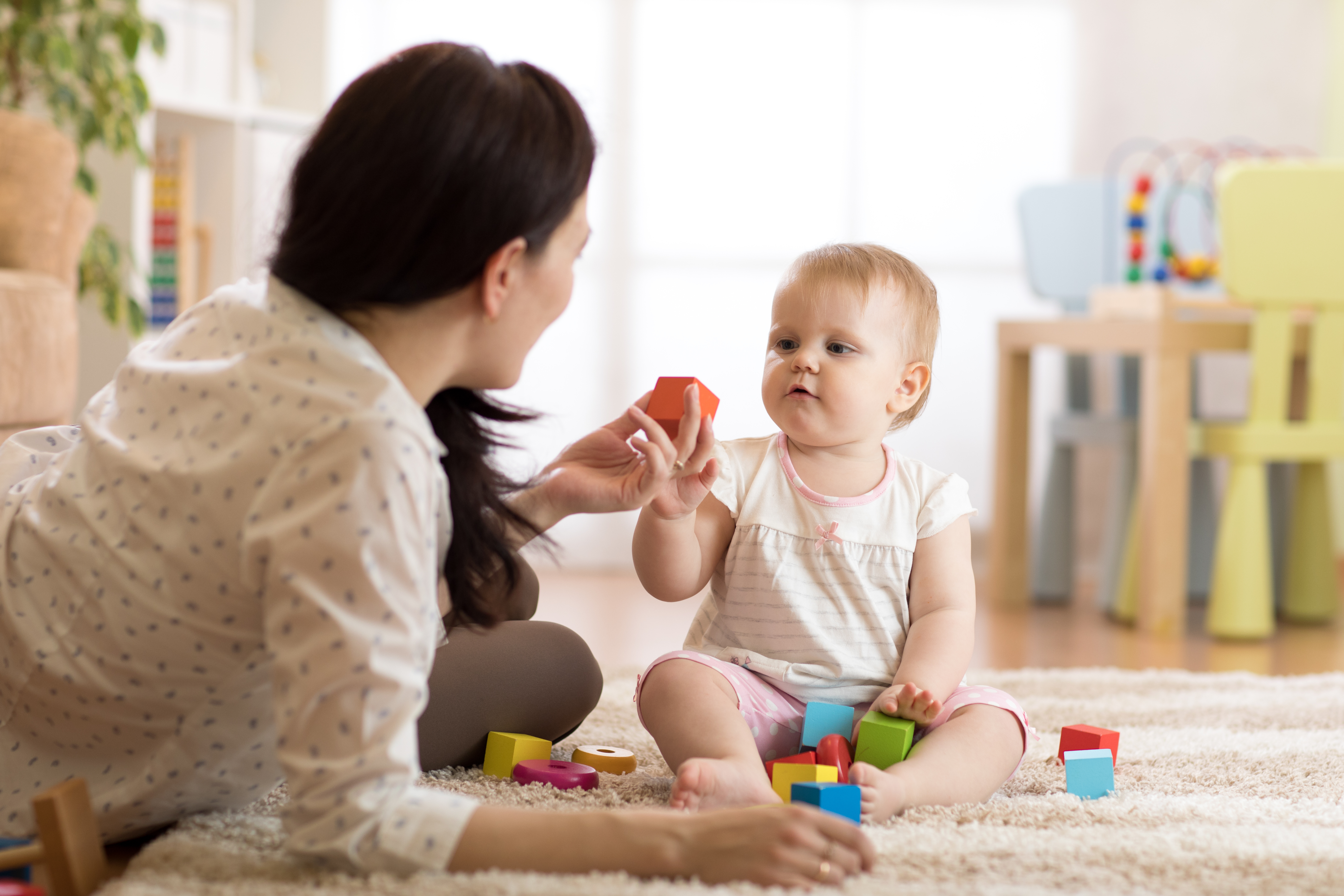 A babysitter is pictured taking care of a baby | Source: Shutterstock