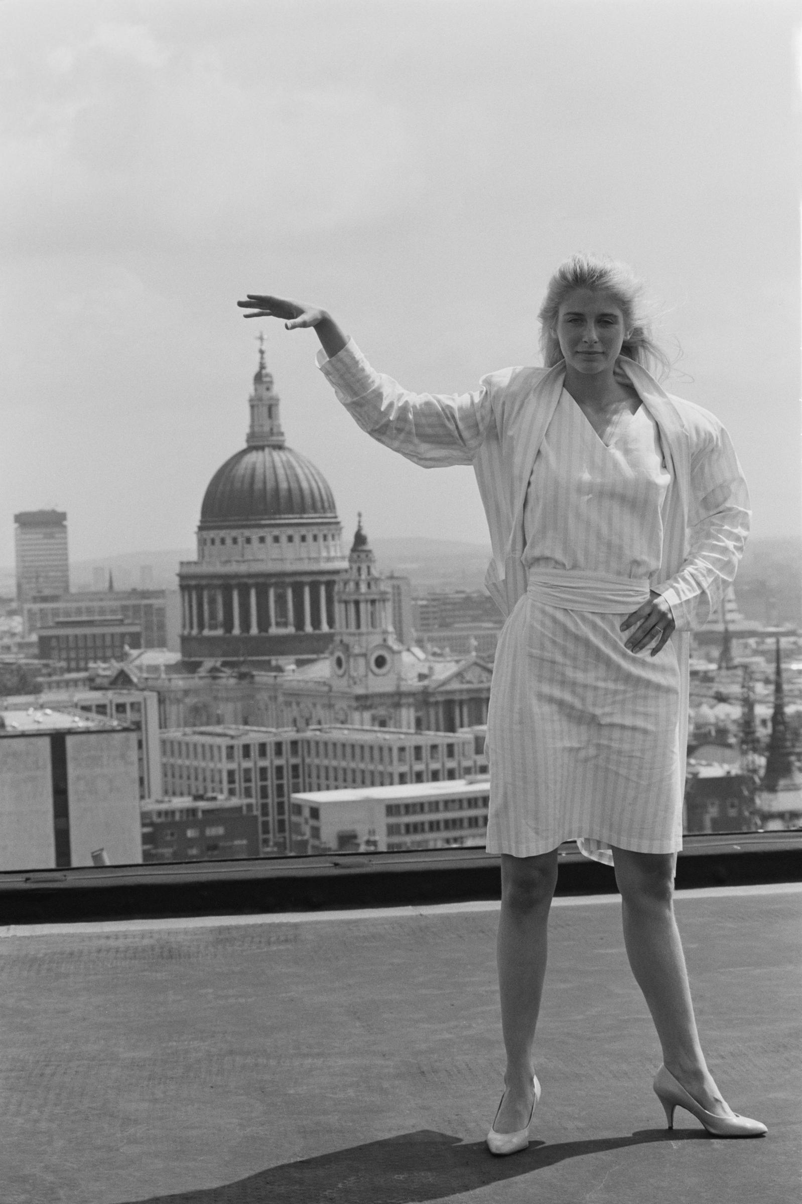 The actress poses on a rooftop as she puts her hand up to match with the top of St Paul's Cathedral on July 16, 1984 in London, England. | Source: Getty Images