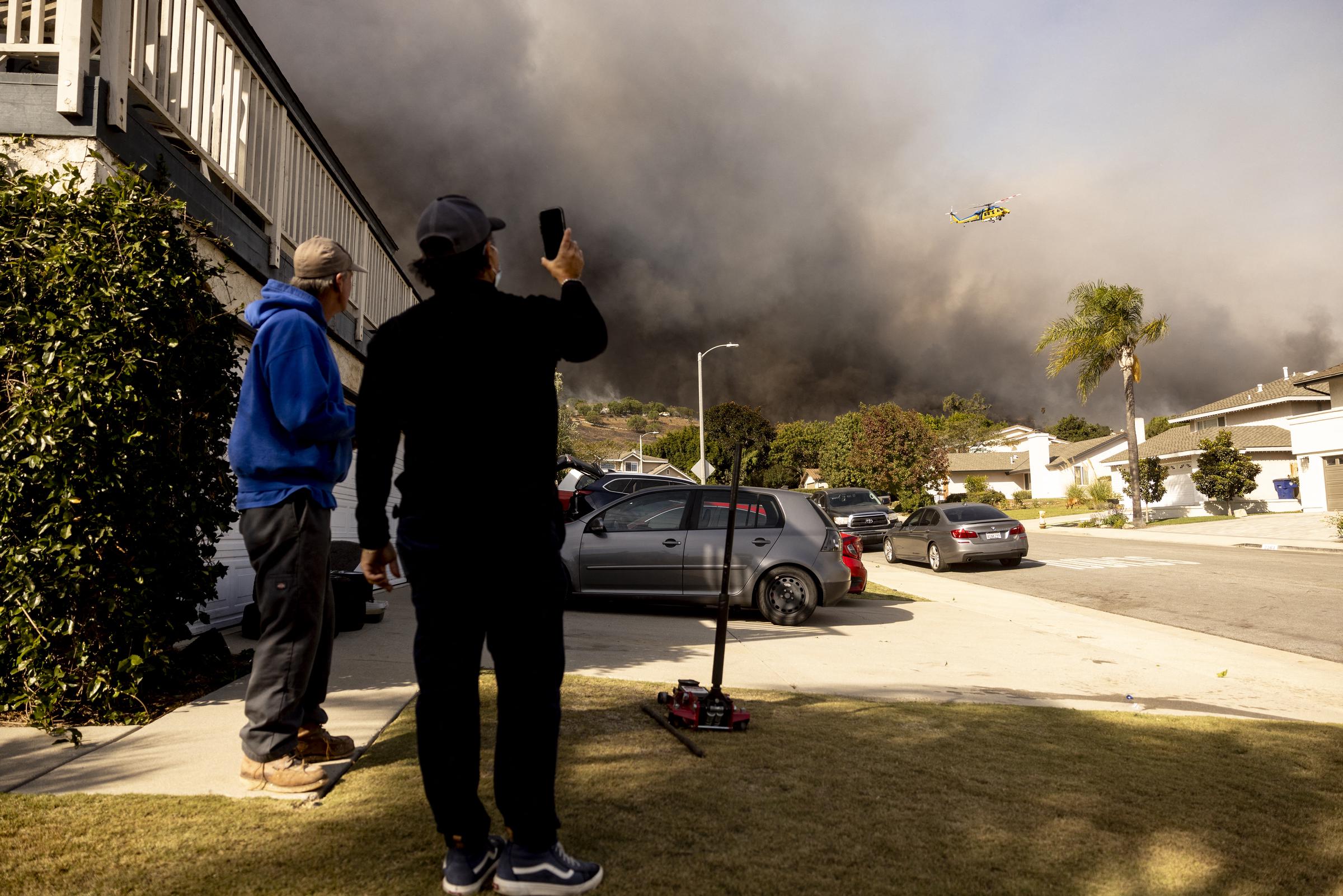 Residents looking on as the Santa Ana wind-fed Mountain Fire rages on in Camarillo, California. | Source: Getty Images