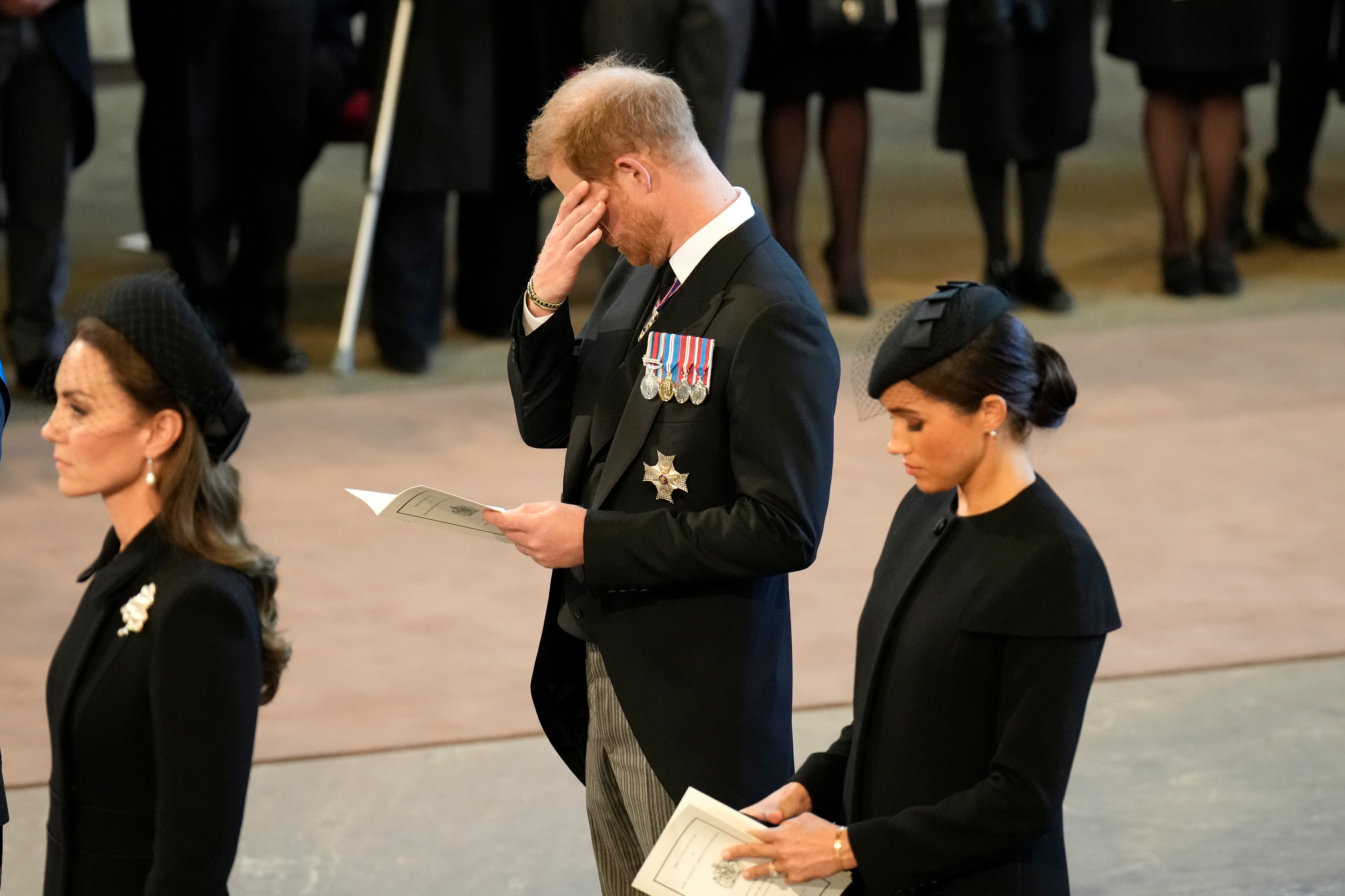 Catherine, Princess of Wales, Prince Harry, and Meghan, Duchess of Sussex were seen walking in solemn reflection through the Palace of Westminster on 14 September 2022, following the procession for the lying-in-state of the late Queen Elizabeth II. Dressed in black and holding service programmes, the trio embodied the weight of the moment, with Prince Harry briefly lowering his head as if overcome with emotion.