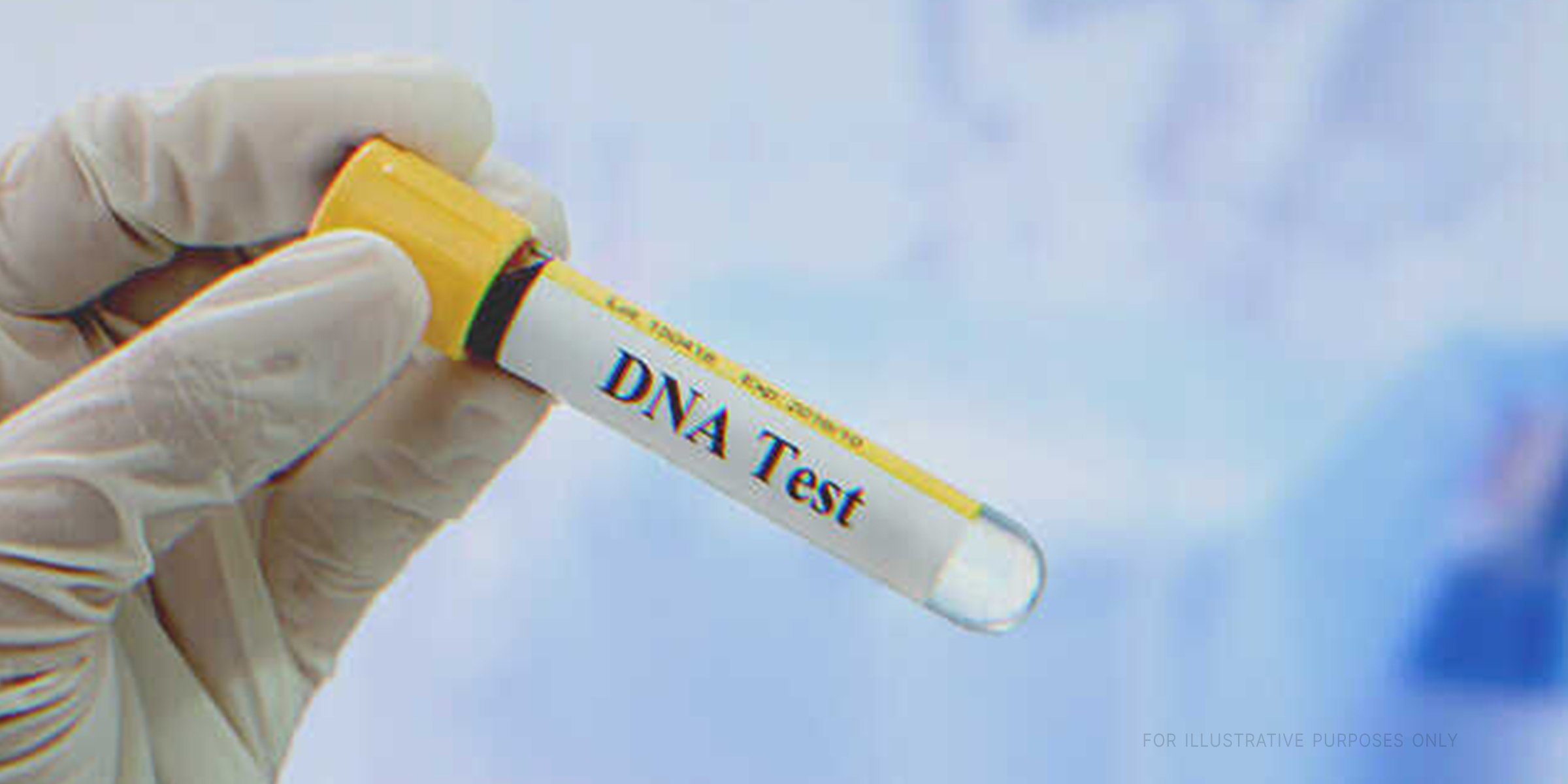 Gloved hand holding vial with "DNA Test" written on the lable. | Shutterstock