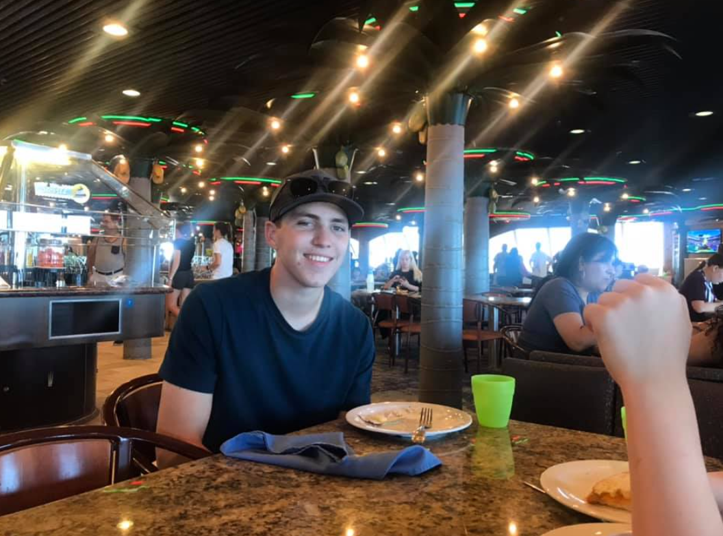 Tyler Robinson smiling while sitting at a restaurant on March 17, 2019 | Source: Facebook/Amber Jones Robinson