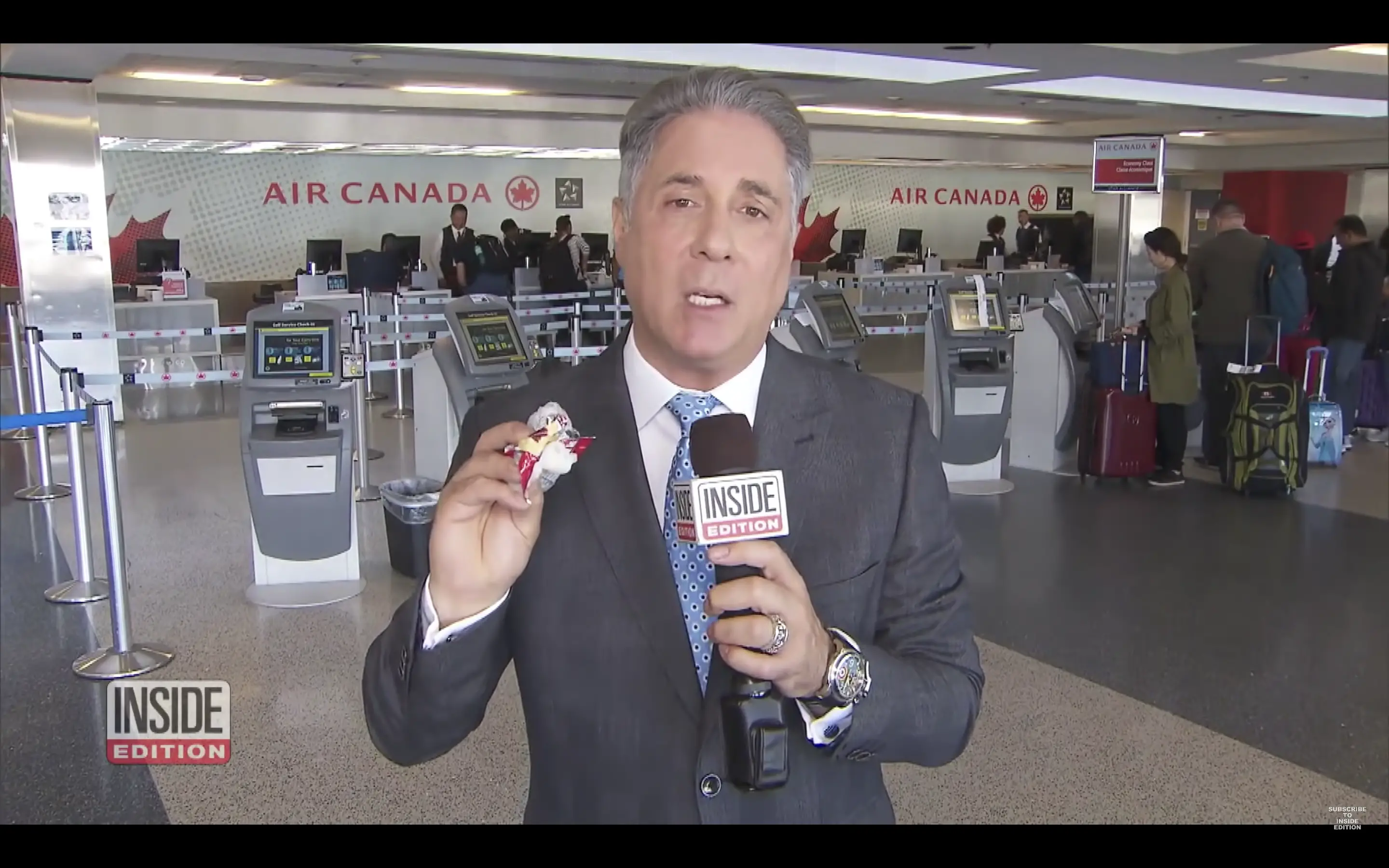 A reporter at the airport | Source: Youtube.com/Inside Edition
