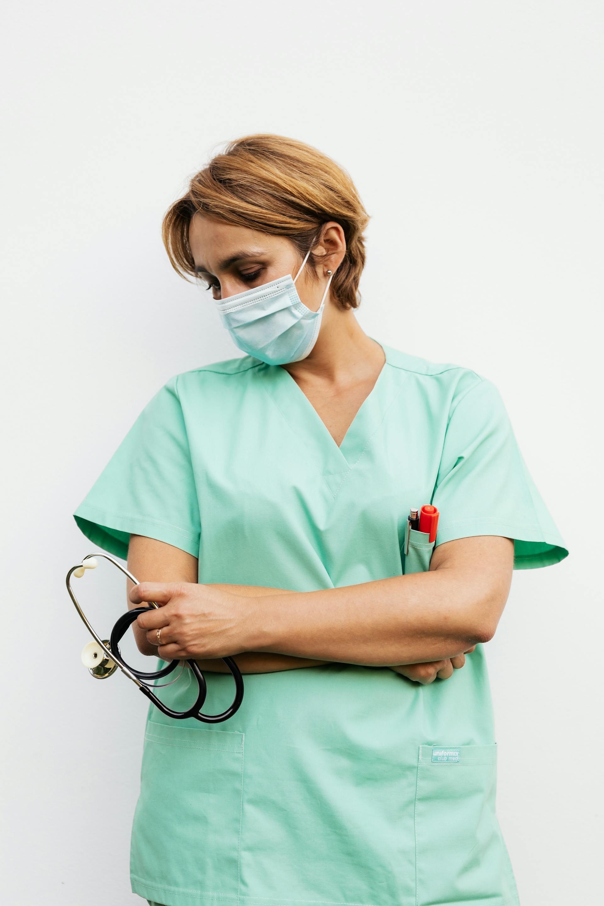 A nurse wearing a face mask while holding a stethoscope | Source: Pexels