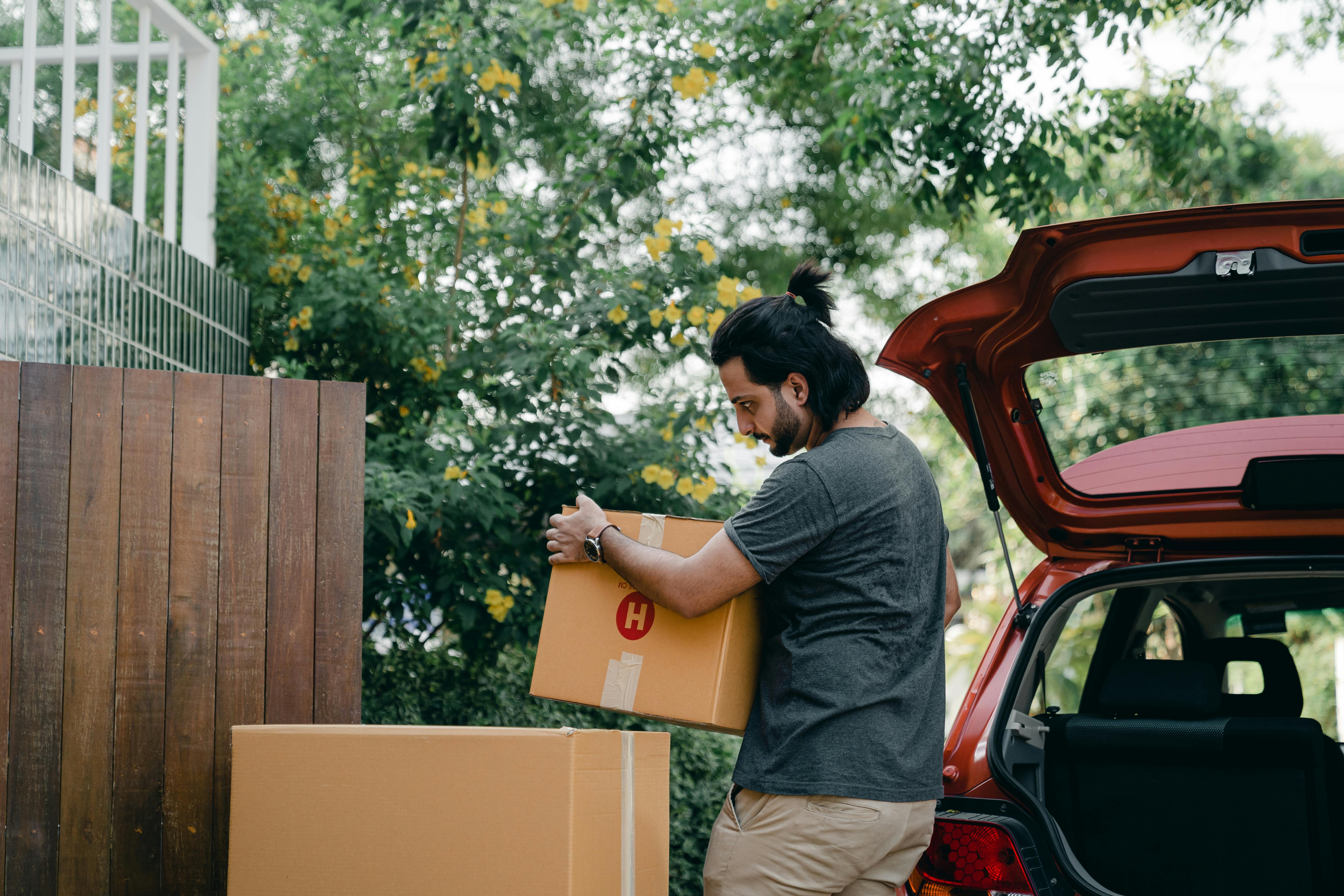 A man packing moving boxes into a car | Source: Pexels