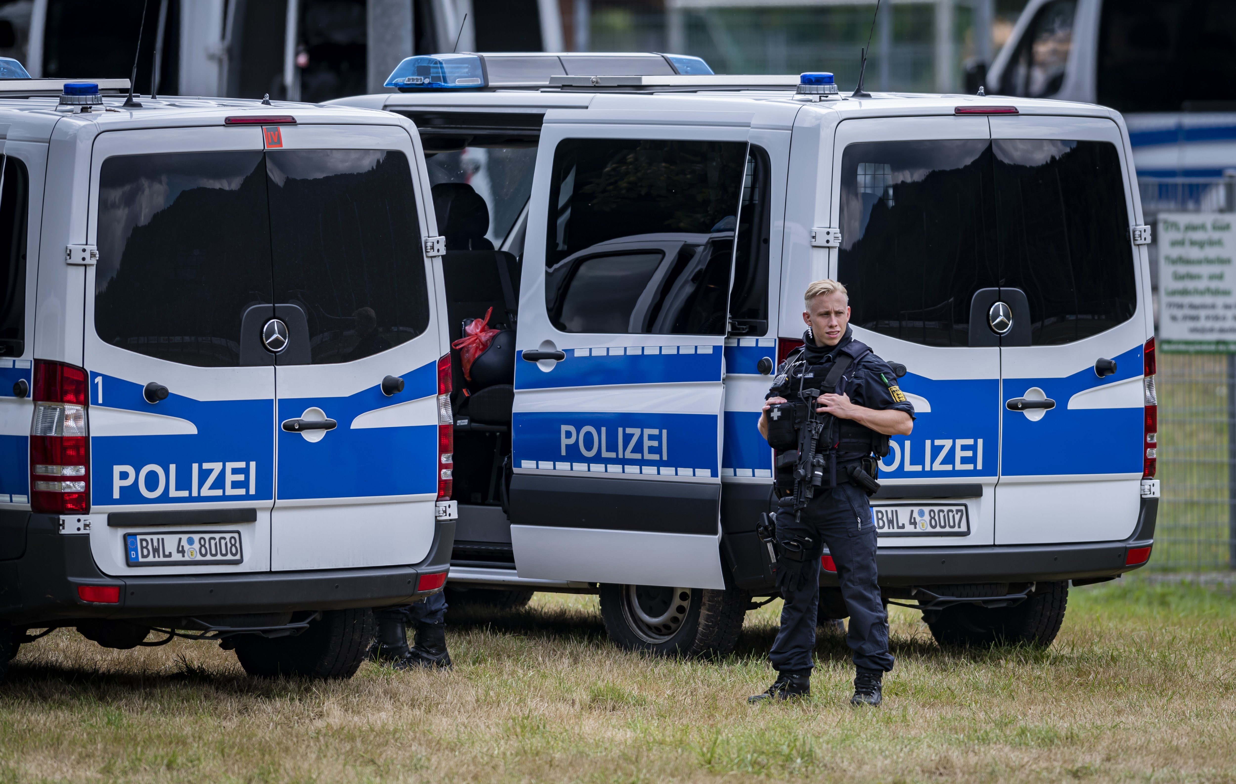 Bewaffnete Polizisten vor Polizeiwagen | Quelle: Getty Images