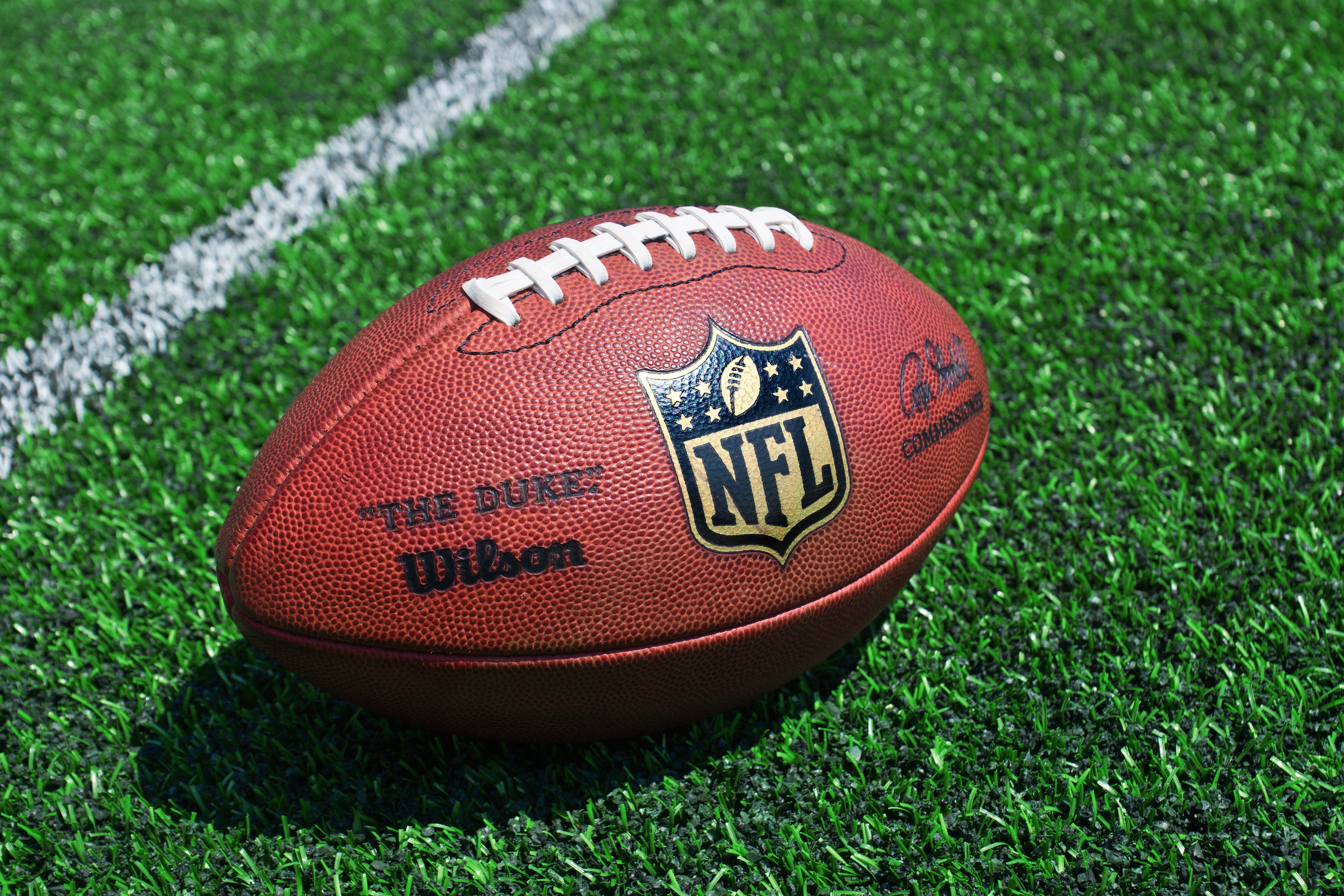 Photo of official NFL football on field.|Source: Shutterstock