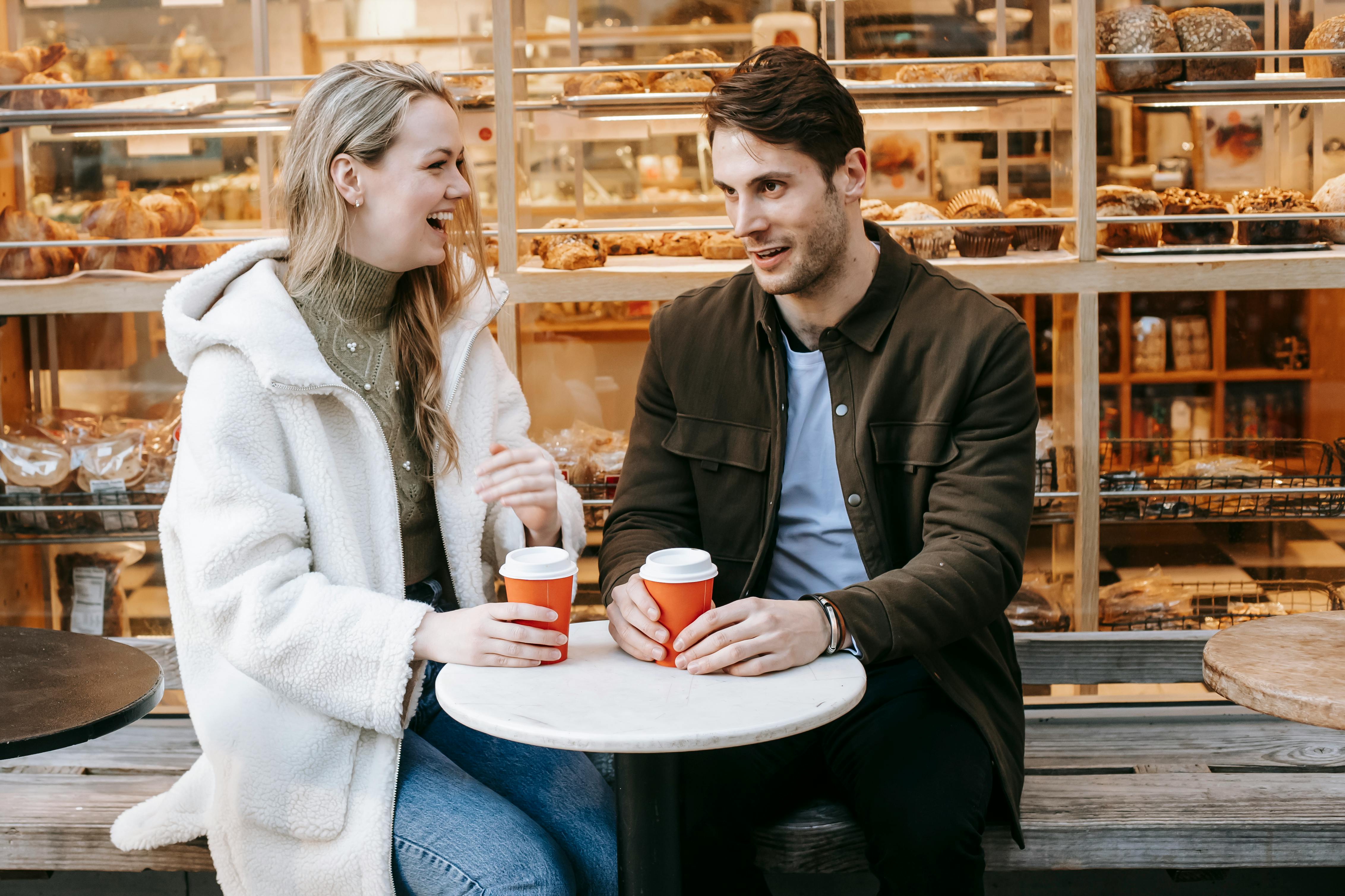 A couple laughing and enjoying coffee | Source: Pexels