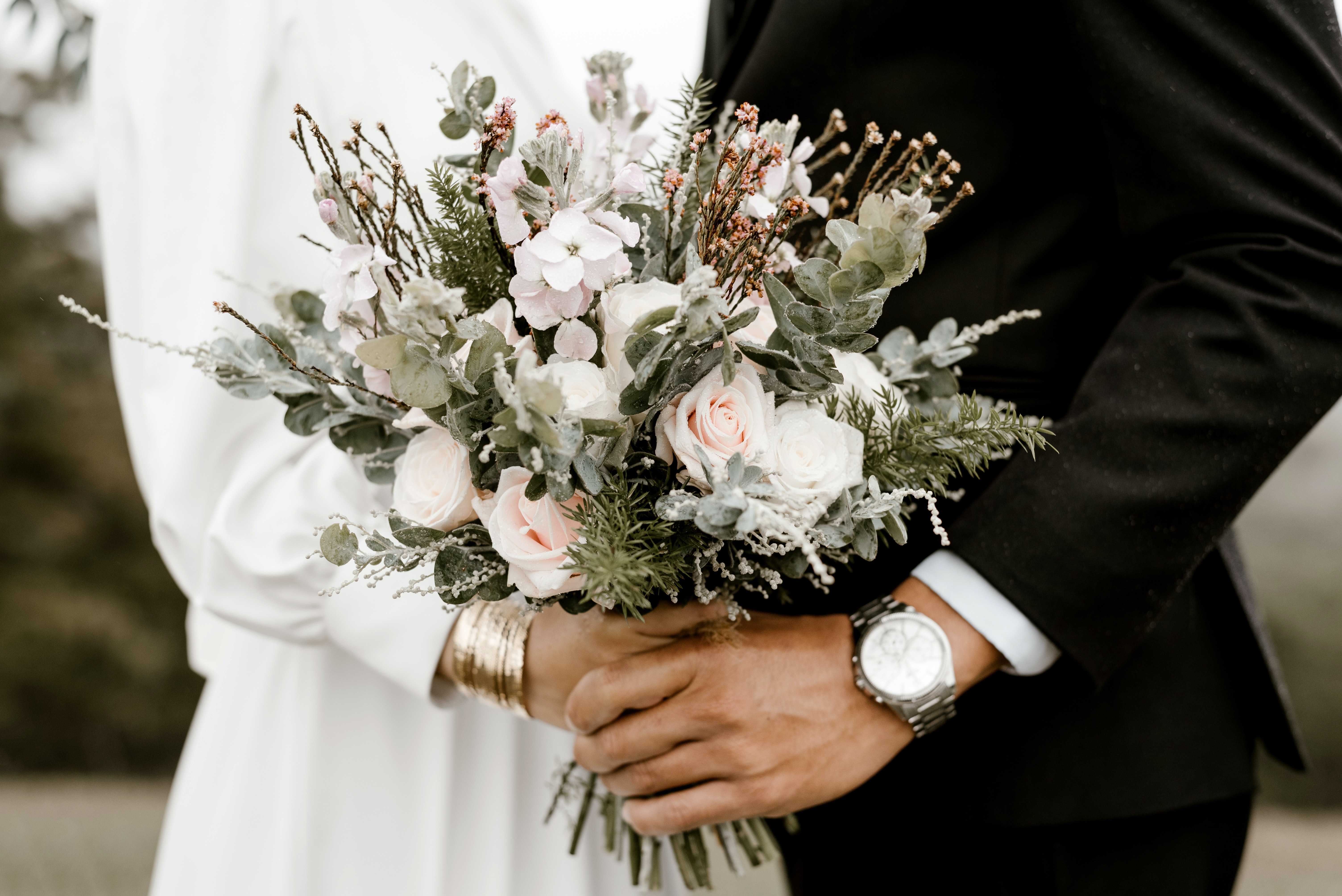 A bride and groom holding a bouquet. | Source: Pexels