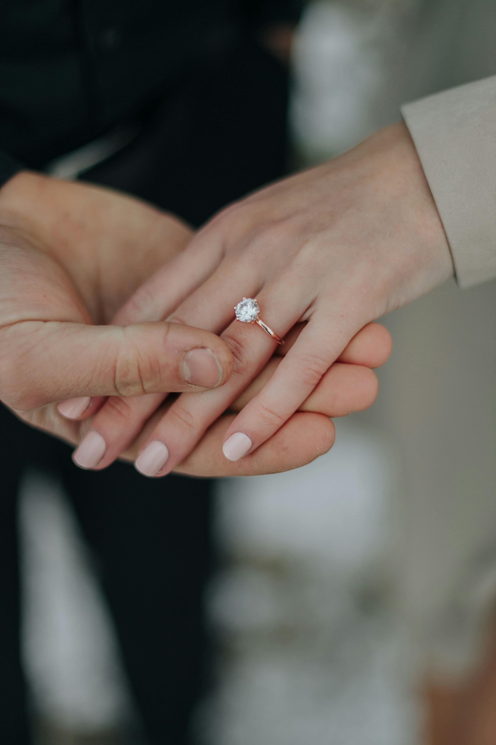 Close-up shot of a woman flaunting her diamond ring while holding her partner's hand | Source: Unsplash