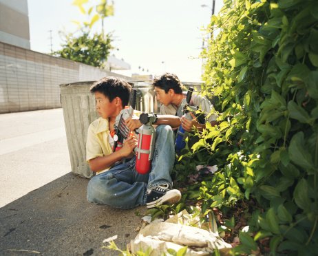 Photo of young boys hiding behind trash cans with water guns | Photo: Getty Images