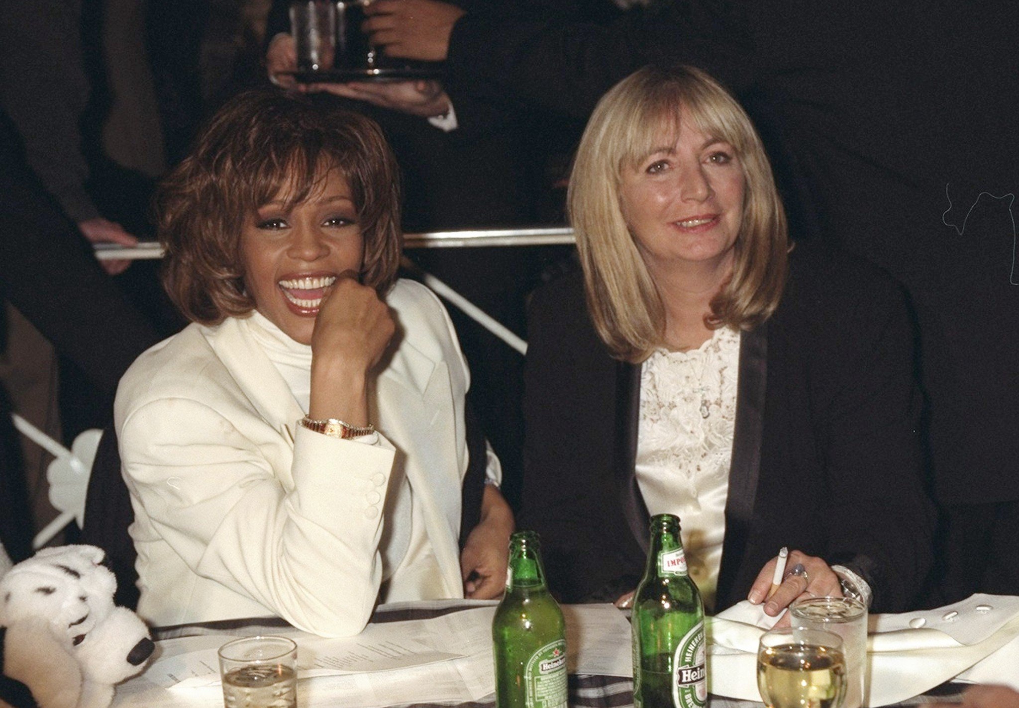 Whitney Houston and Penny Marshall share a table at the premiere of the movie "The Preacher's Wife" at Roseland, December 13, 1996 | Source: Getty Images