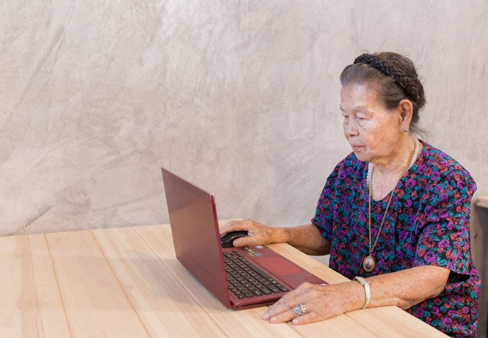 Mujer mayor sentada frente a una computadora portátil. | Foto: Shutterstock