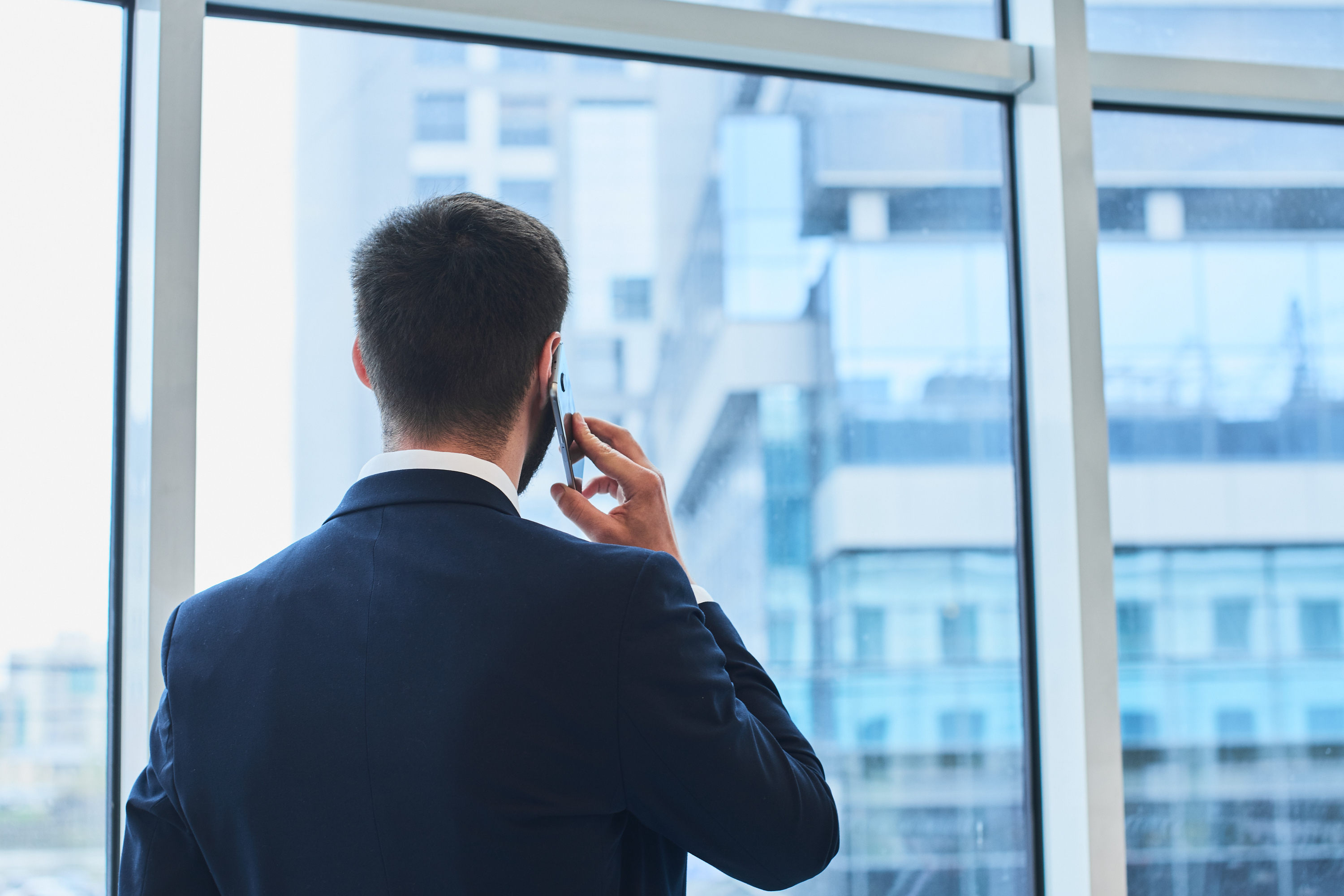 Talking on cell phone and looking out the window. | Source: Shutterstock