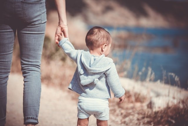 Parent holding child's hands | Source: Unsplash
