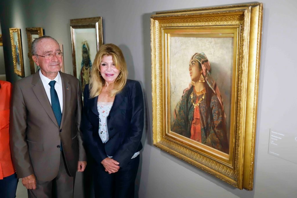 El alcalde de Málaga, Francisco de la Torre, y la presidenta de la Fundación Palacio Villalón, Carmen Cervera, son vistos junto a una pintura durante la inauguración de la Exposición 'Fantasia Arabe' el 11 de octubre de 2019 en Málaga, España. | Foto: Getty Images.