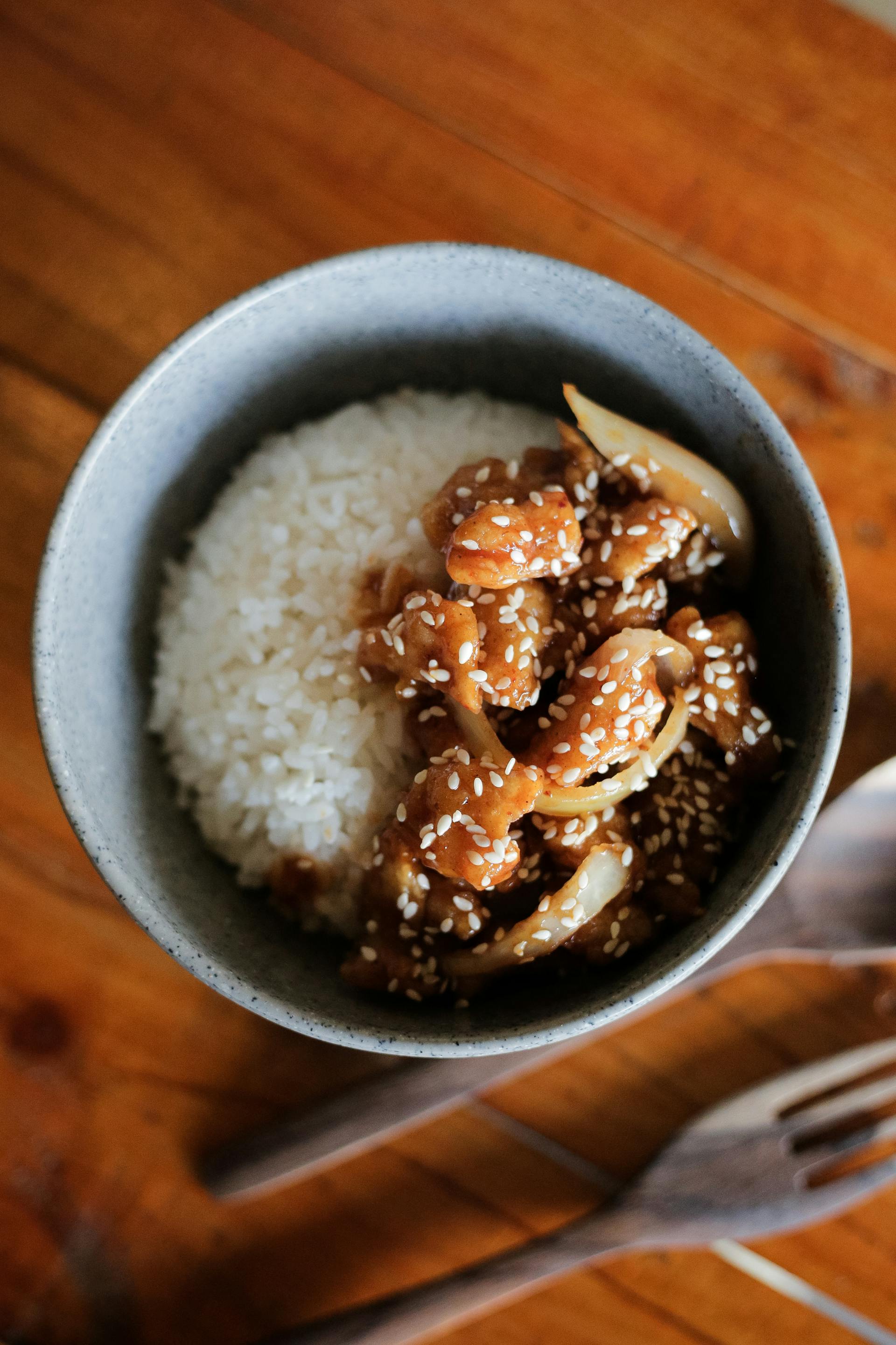 A bowl of sesame chicken with rice | Source: Pexels