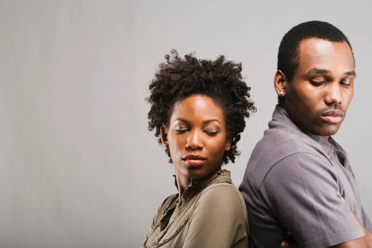 An angry African American couple standing back to back | Source: Getty Images
