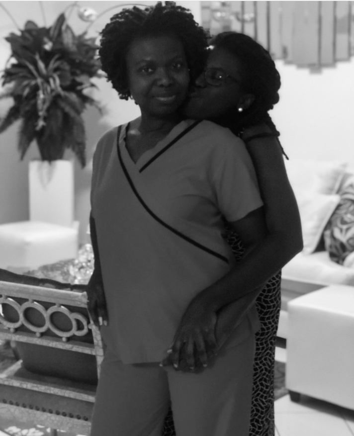 Captured in a tender black-and-white moment, Nancy Metayer Bowen wraps her arms around her mother from behind, planting a gentle kiss on her cheek as they share a quiet, affectionate embrace. | Source: Instagram/nancymetayerbowen