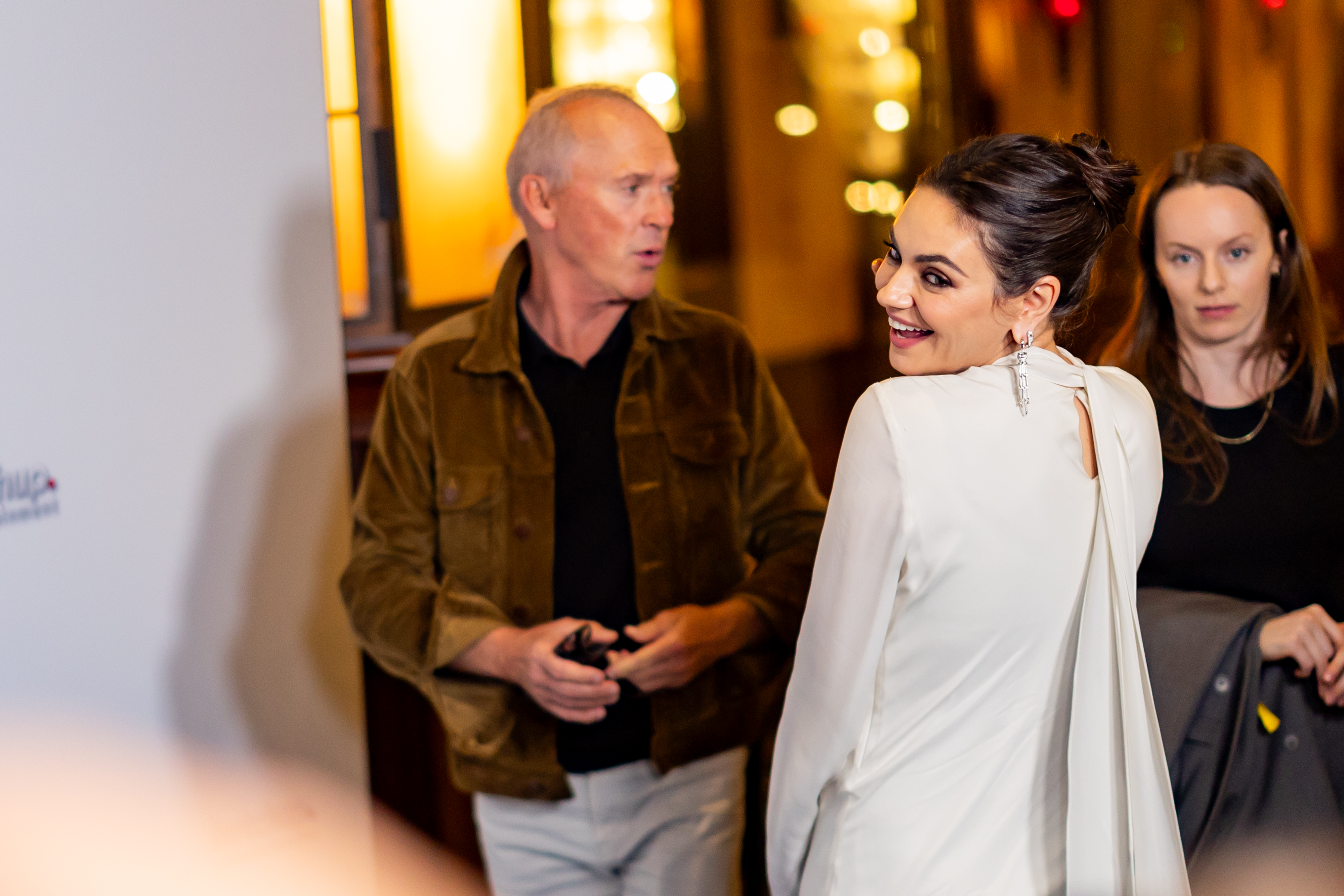 Michael Keaton, Mila Kunis, and an unidentified woman. | Source: Getty Images