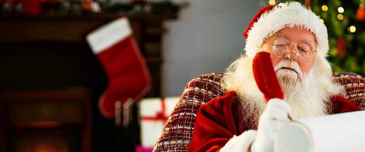 Weihnachtsmann schreibt auf Pergament | Quelle: Shutterstock