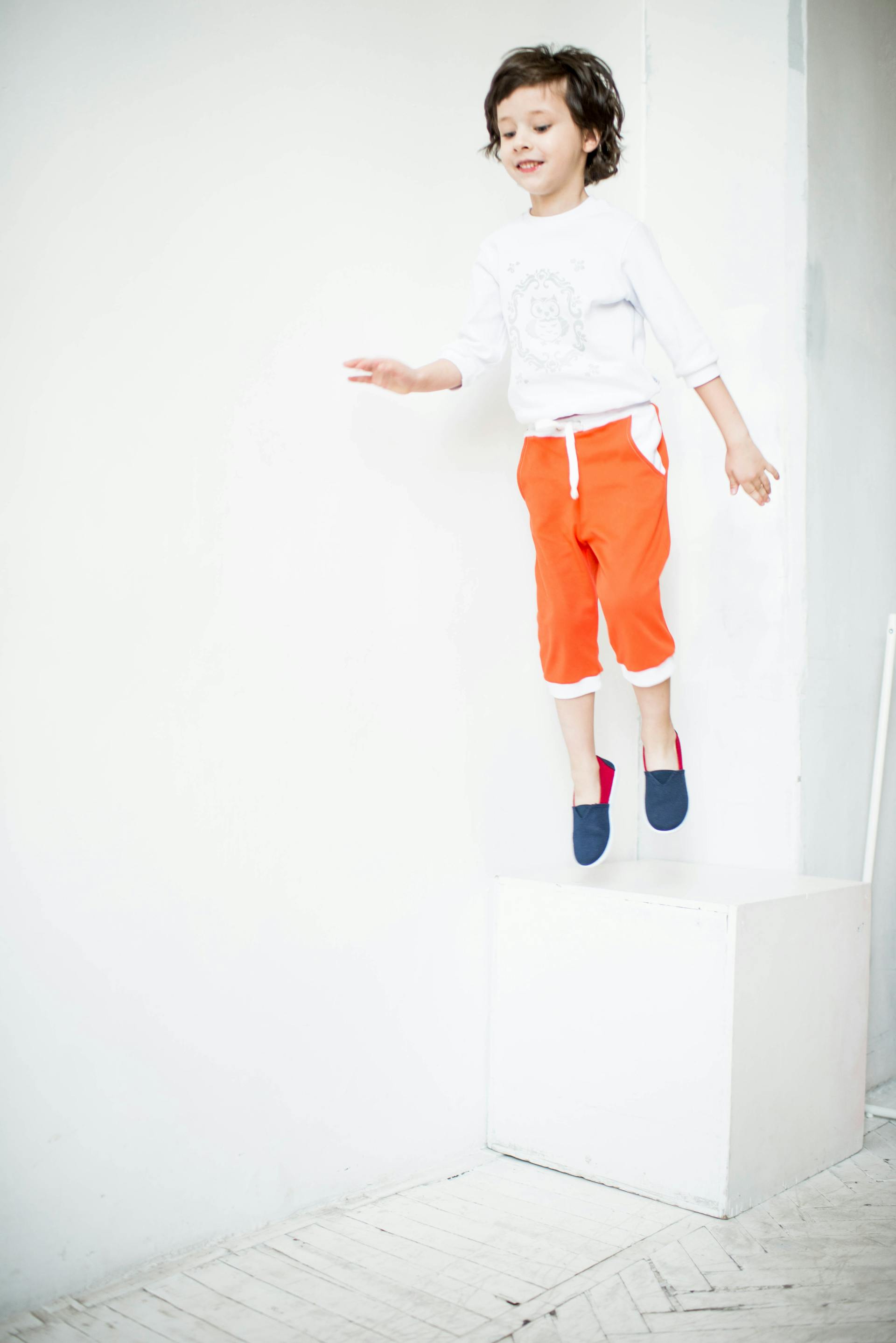 A boy jumping in a room | Source: Pexels