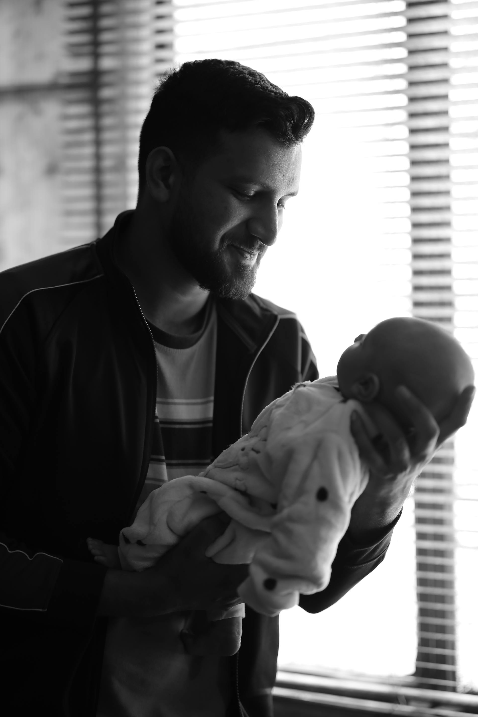 Grayscale photo of a father holding a newborn baby | Source: Pexels