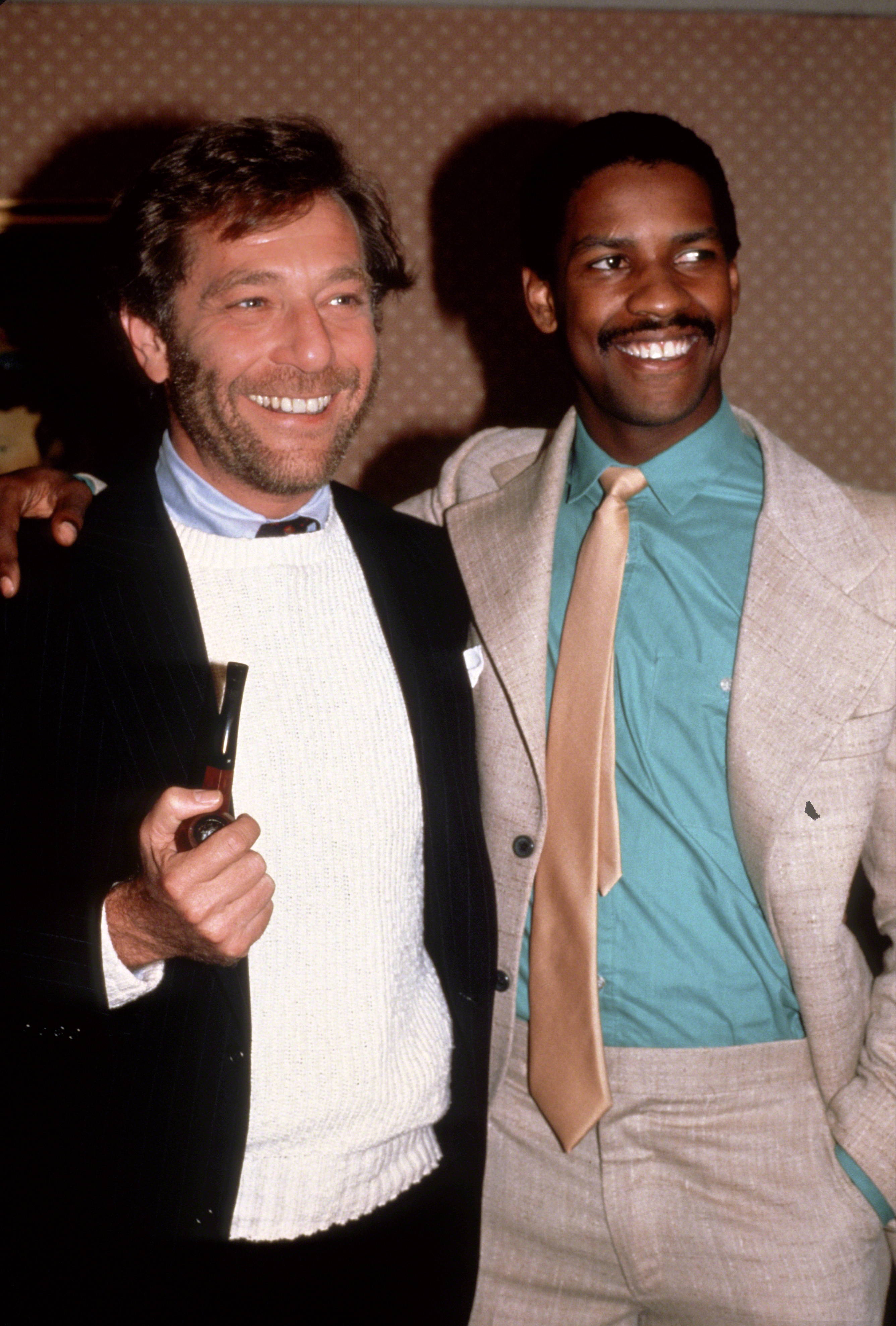 Denzel Washington stands alongside actor George Segal at a "Carbon Copy" screening in New York City. Washington's close-cropped hair and pencil mustache highlight his fresh-faced charisma during his film debut era.