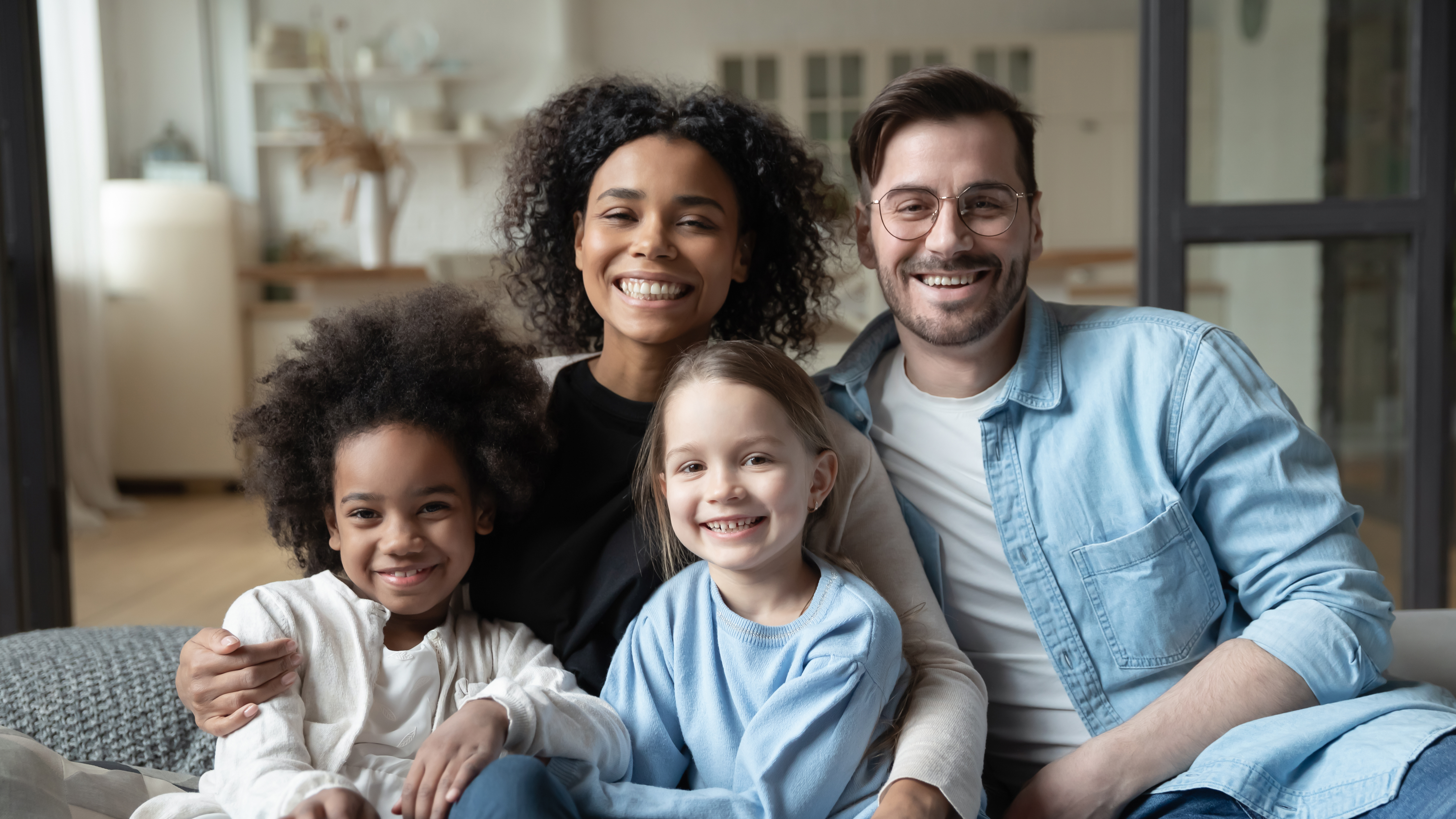 Eine gemischtrassige Familie, bestehend aus einem Vater, einer Mutter und ihren beiden Kindern | Quelle: Shutterstock