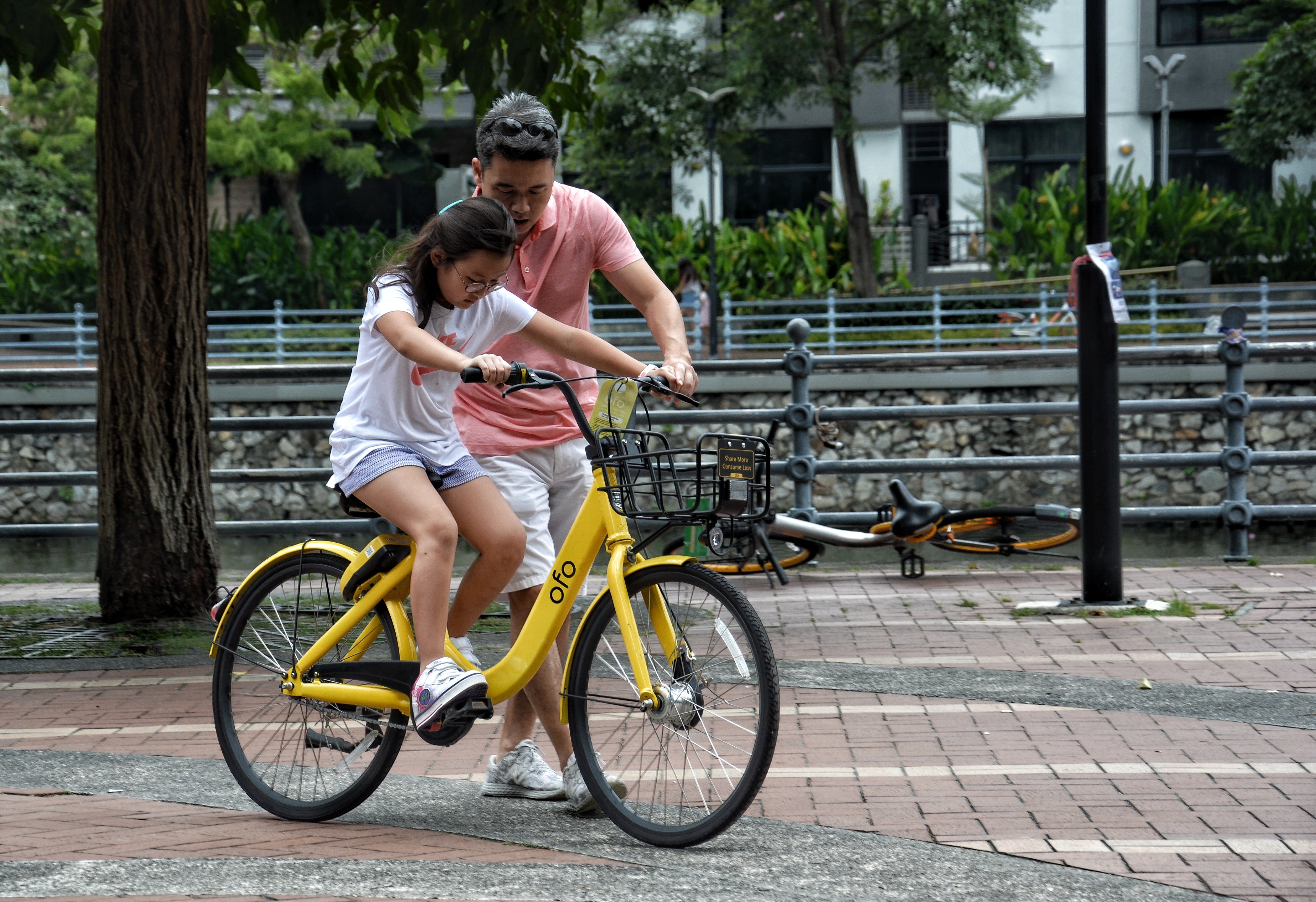 Padre enseñado a su hija a andar en bicicleta. | Foto: Pexels