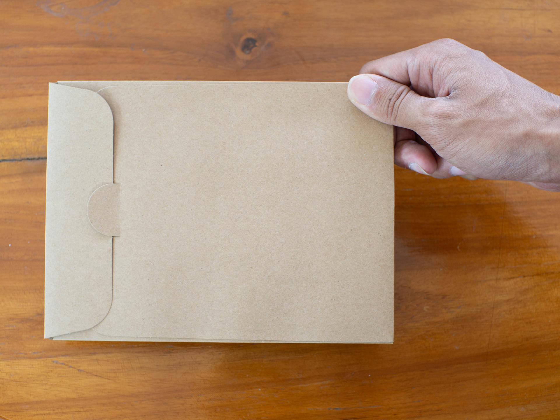 Person holding a brown envelope | Source: Pexels