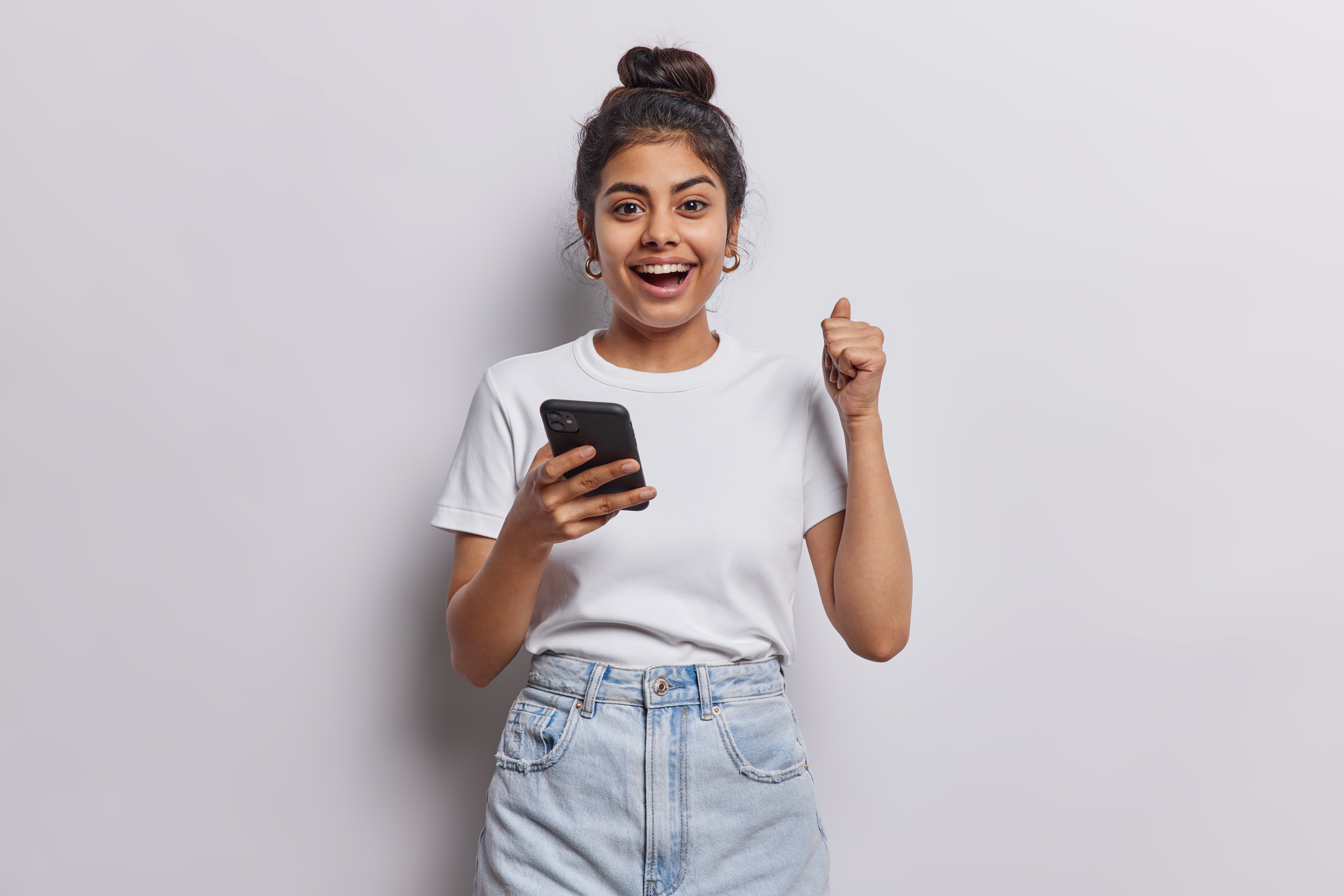 Cheerful young woman showing a thumbs up while on her phone | Source: Shutterstock