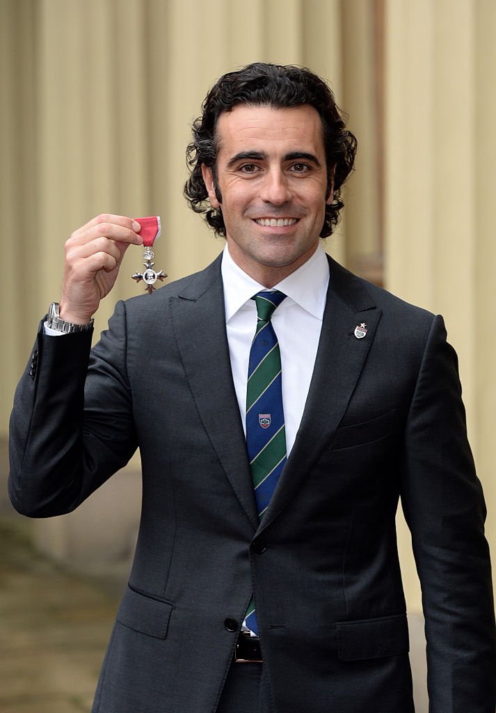 Dario Franchitti holds his Member of the Order of the British Empire (MBE) after the Investiture ceremony at Buckingham Palace on November 26, 2014 | Photo: Getty Images