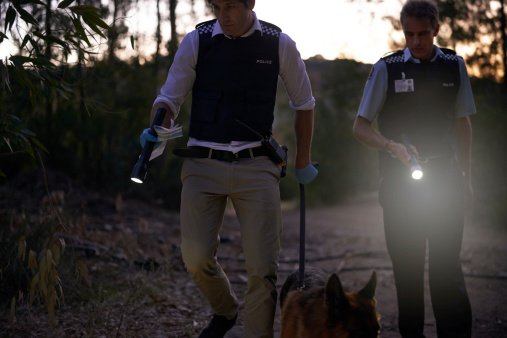 Shot of two policemen looking for evidence | Photo: Getty Images